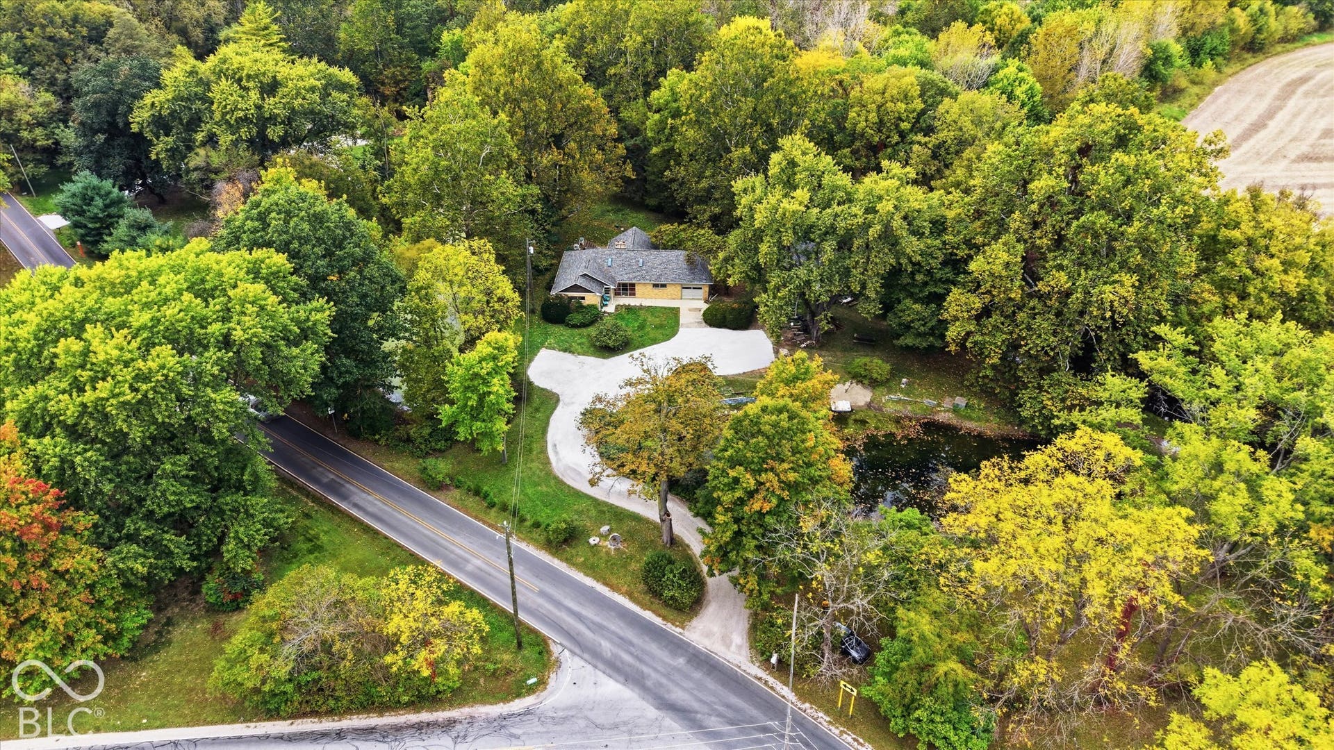 Residential property with a single-story structure, a paved driveway, and mature landscaping