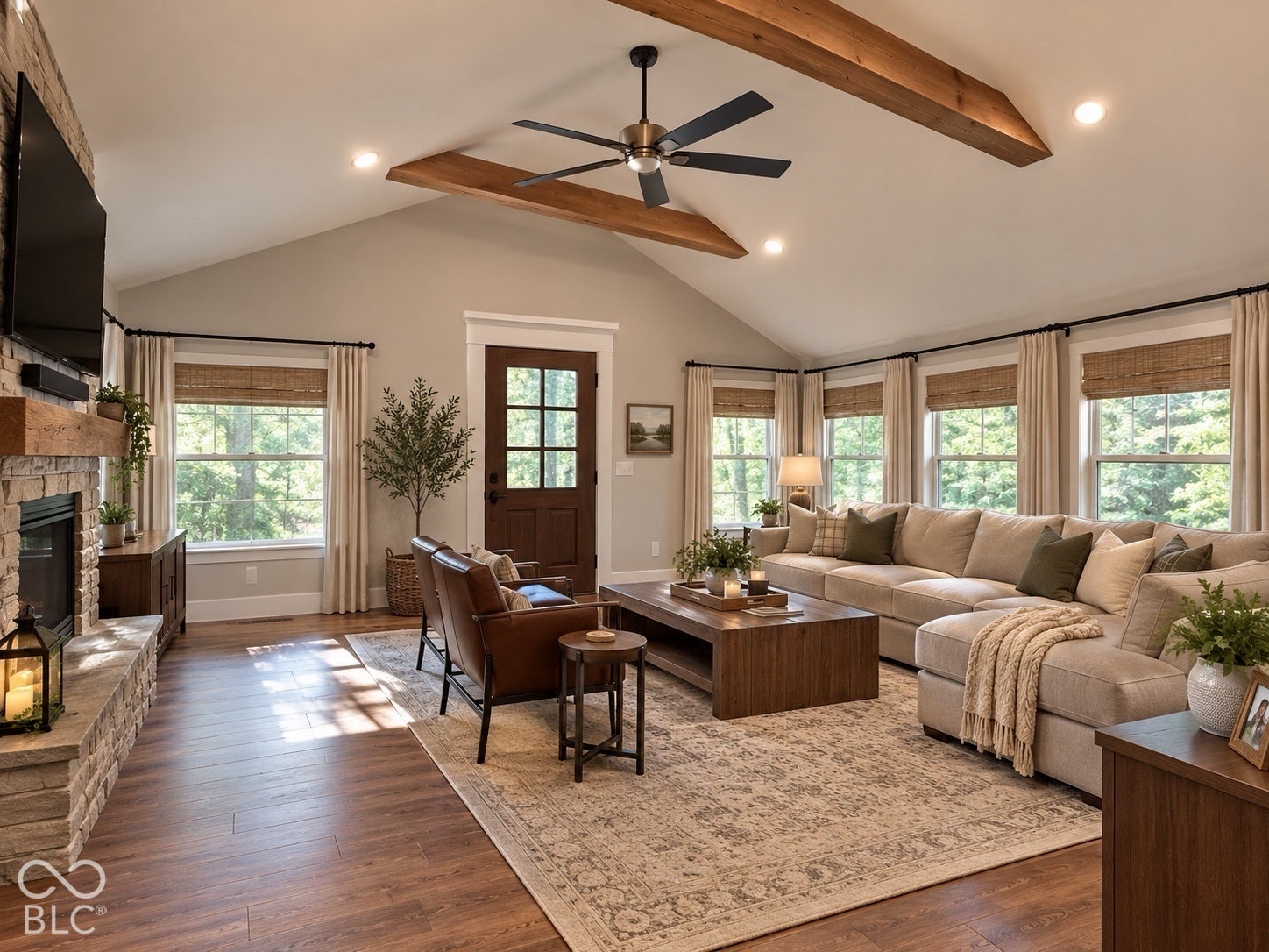 Virtually Altered - Vaulted ceilings featuring exposed wood beams, stone-surround fireplace, wood-finish flooring, multi-pane entry door, and recessed lighting