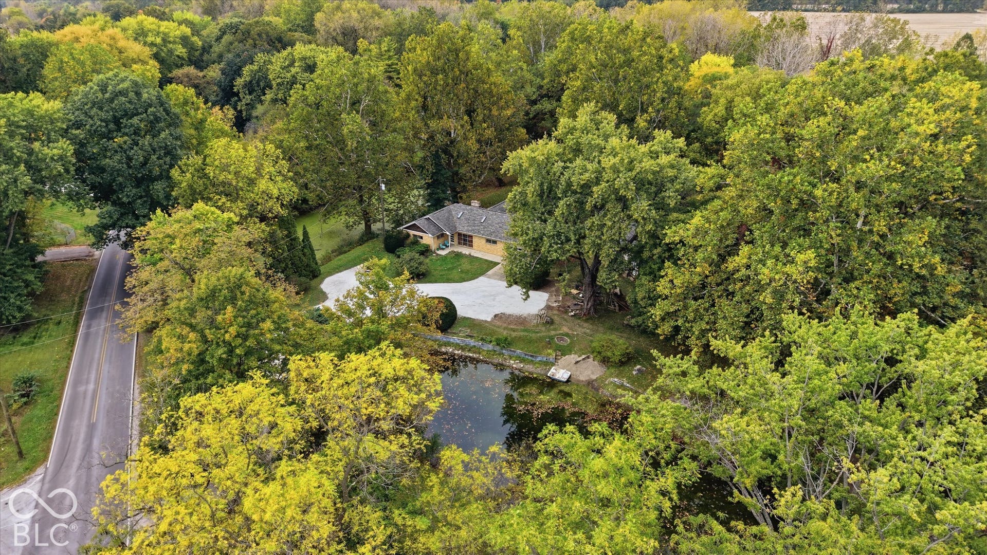 Surrounded by mature trees, this property features a residence  on  Little Eagle Creek, with 2 ponds and a 2 story barn