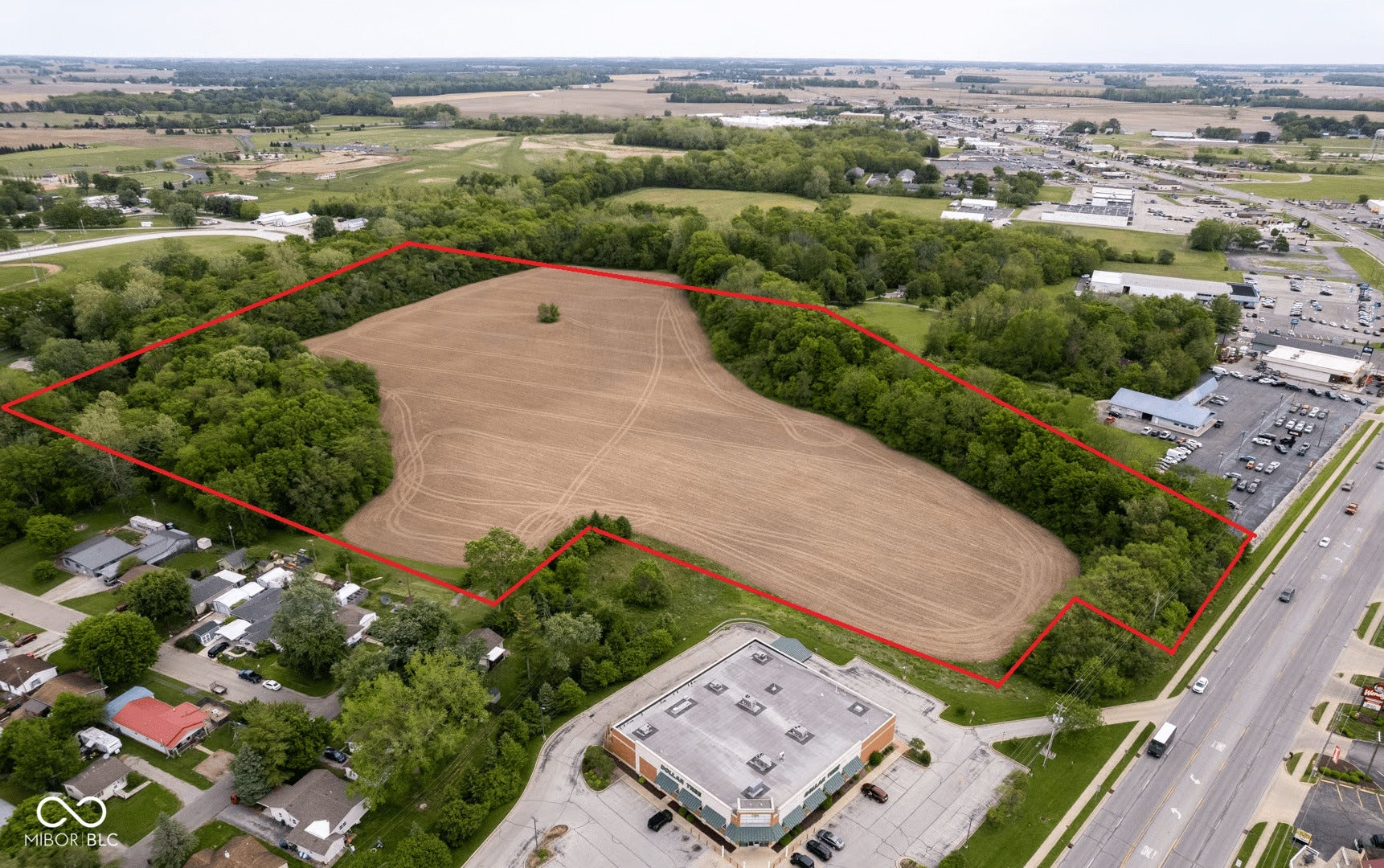 Expansive agricultural land featuring approximately 40+ acres of cleared, tillable soil bordered by mature tree lines