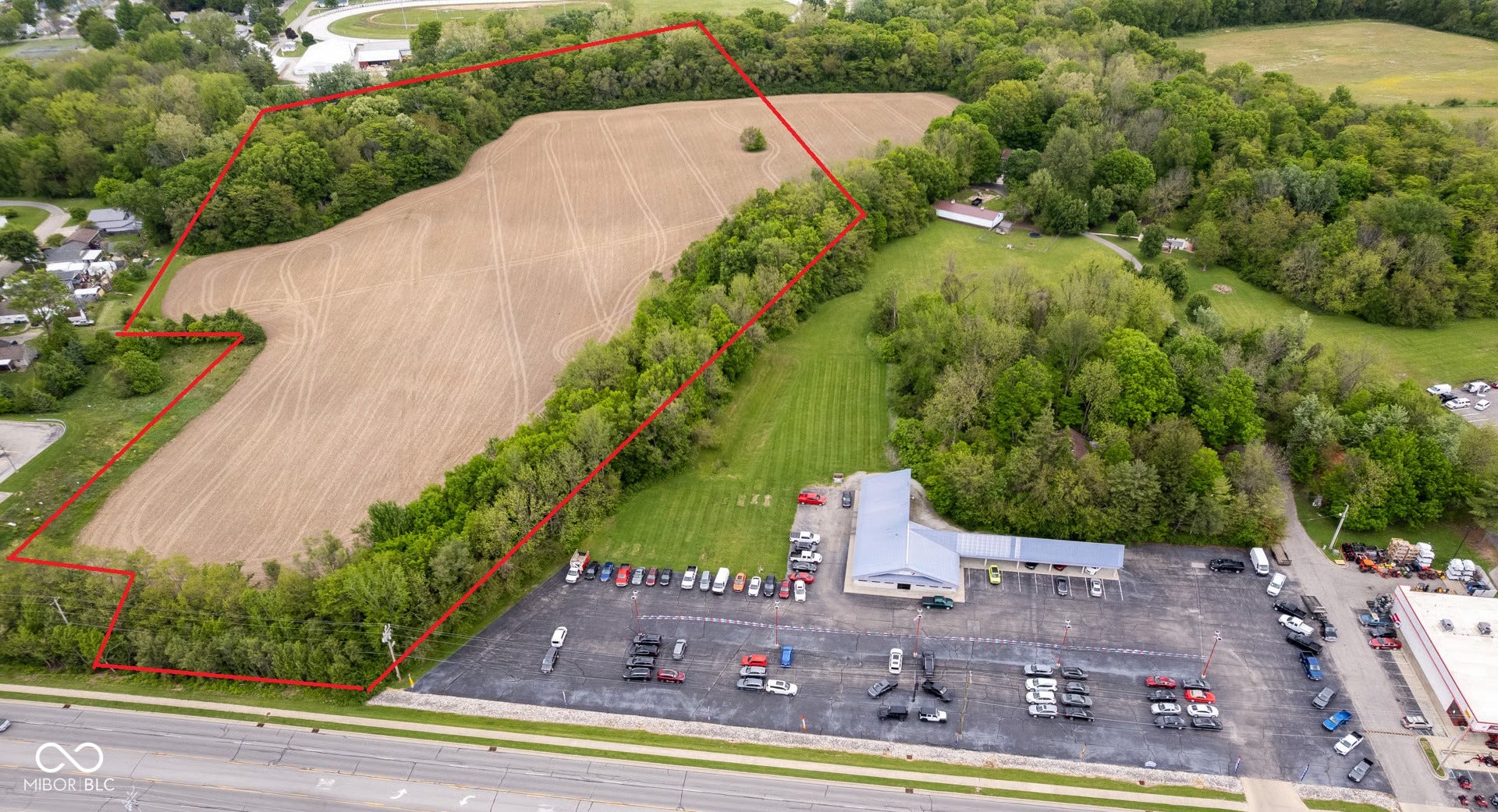 Expansive land parcel featuring open fields and mature tree lines
