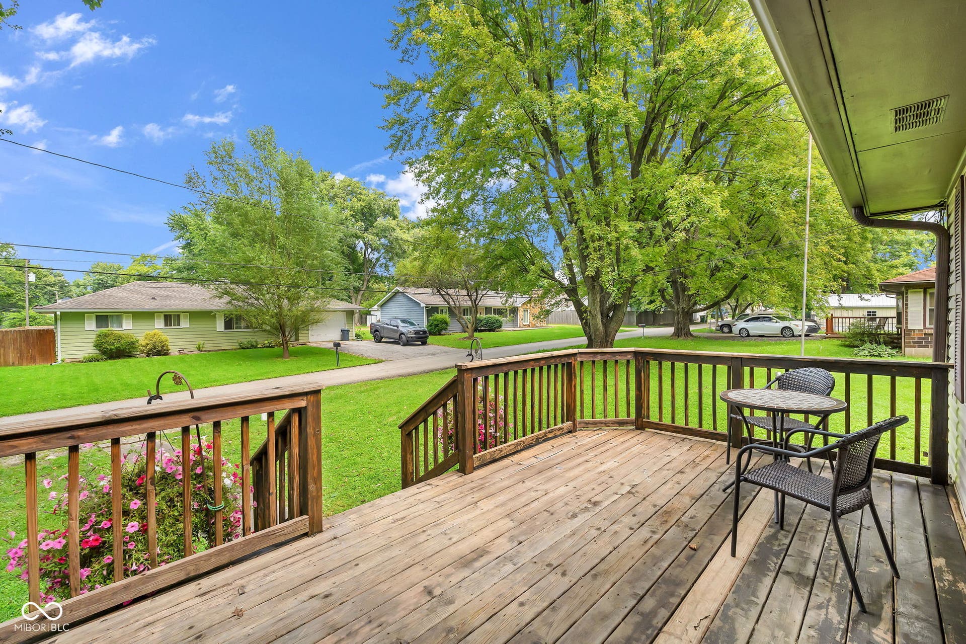 Expansive wood-finish deck with railings, offering outdoor living space