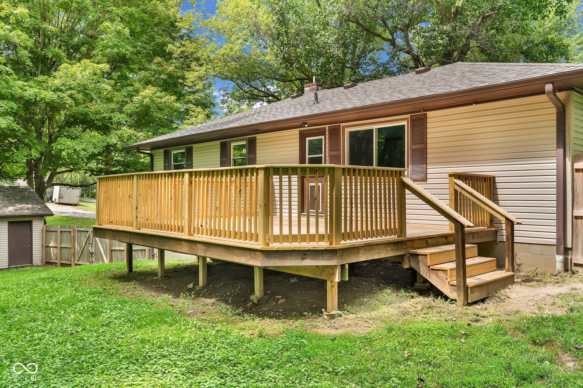 Expansive wood deck with stairs, siding exterior, shingle roof, and sliding glass door access