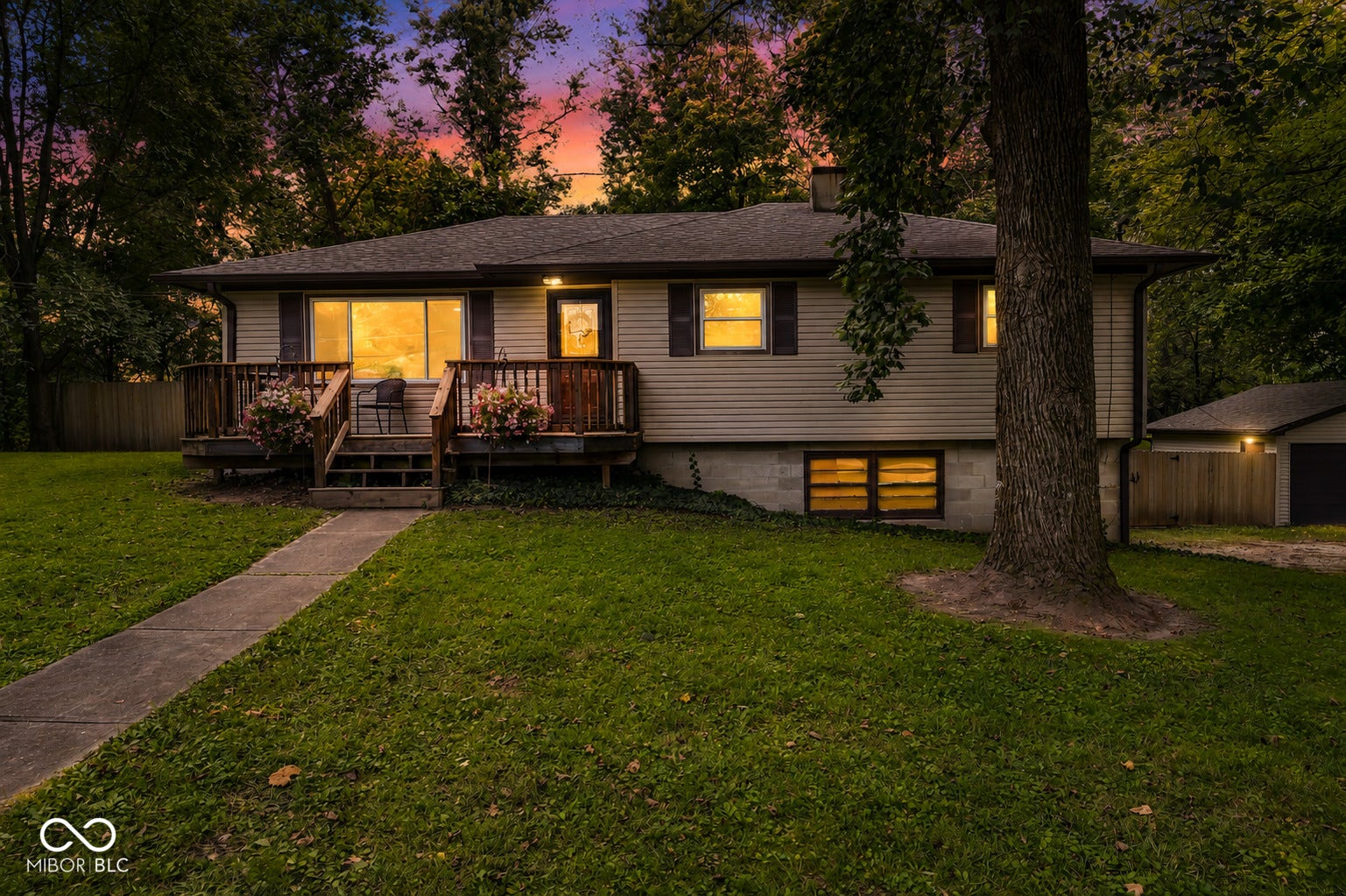 Siding exterior with a covered front porch, concrete walkway, and attached garage