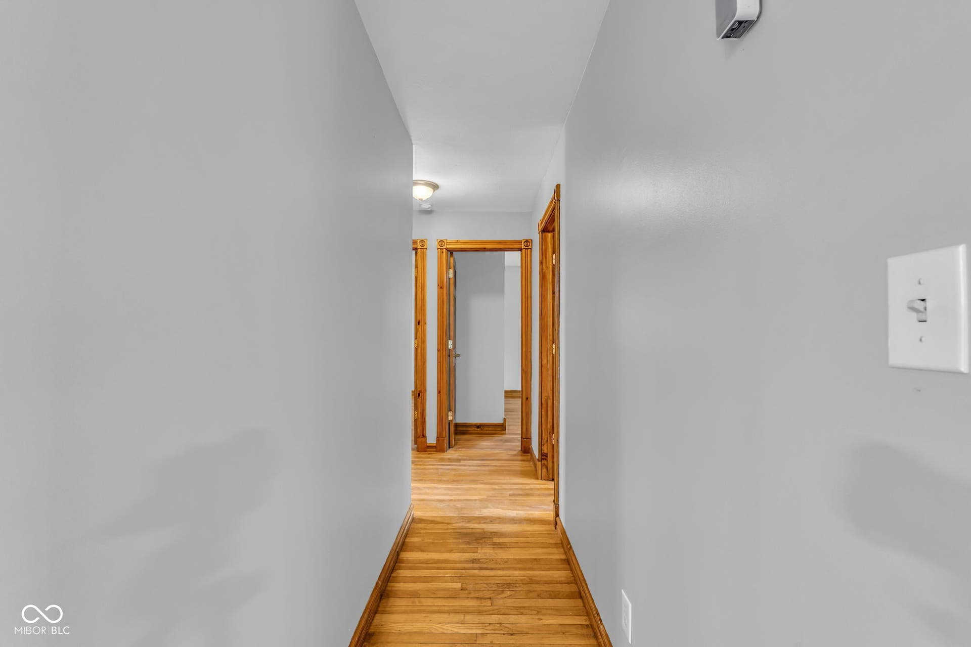 Hardwood flooring complemented by light-toned wall finishes and wood-finish door frames