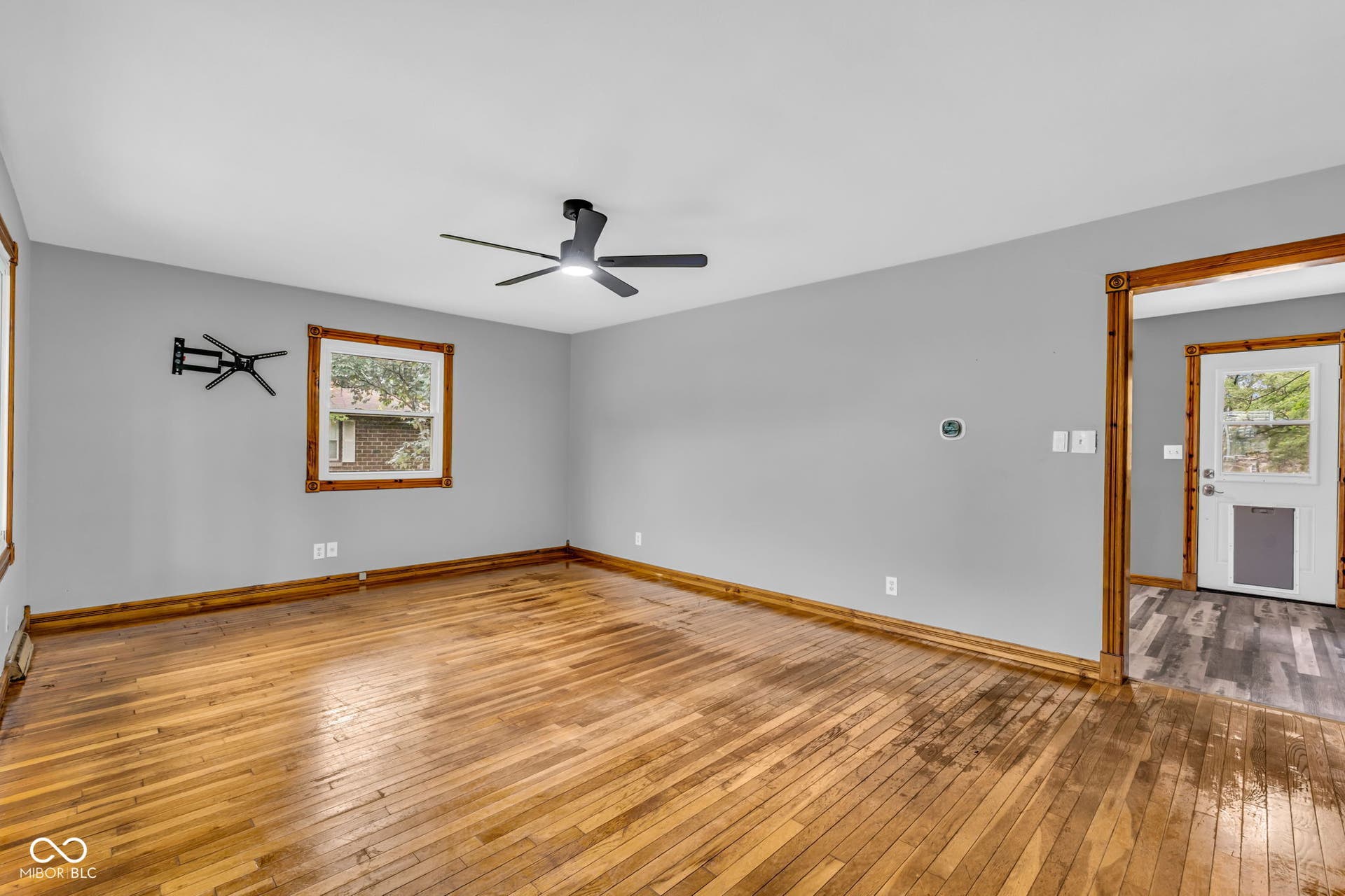 Hardwood flooring, painted walls, ceiling fan, and wood trim