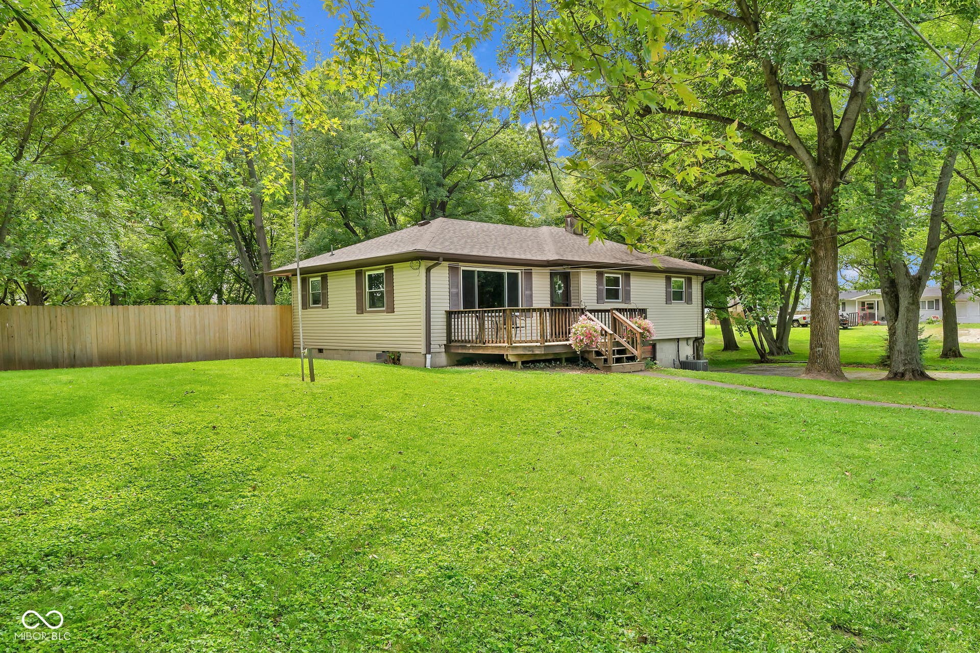 Ranch-style residence featuring a wood deck, sliding glass door, and a shingled roof