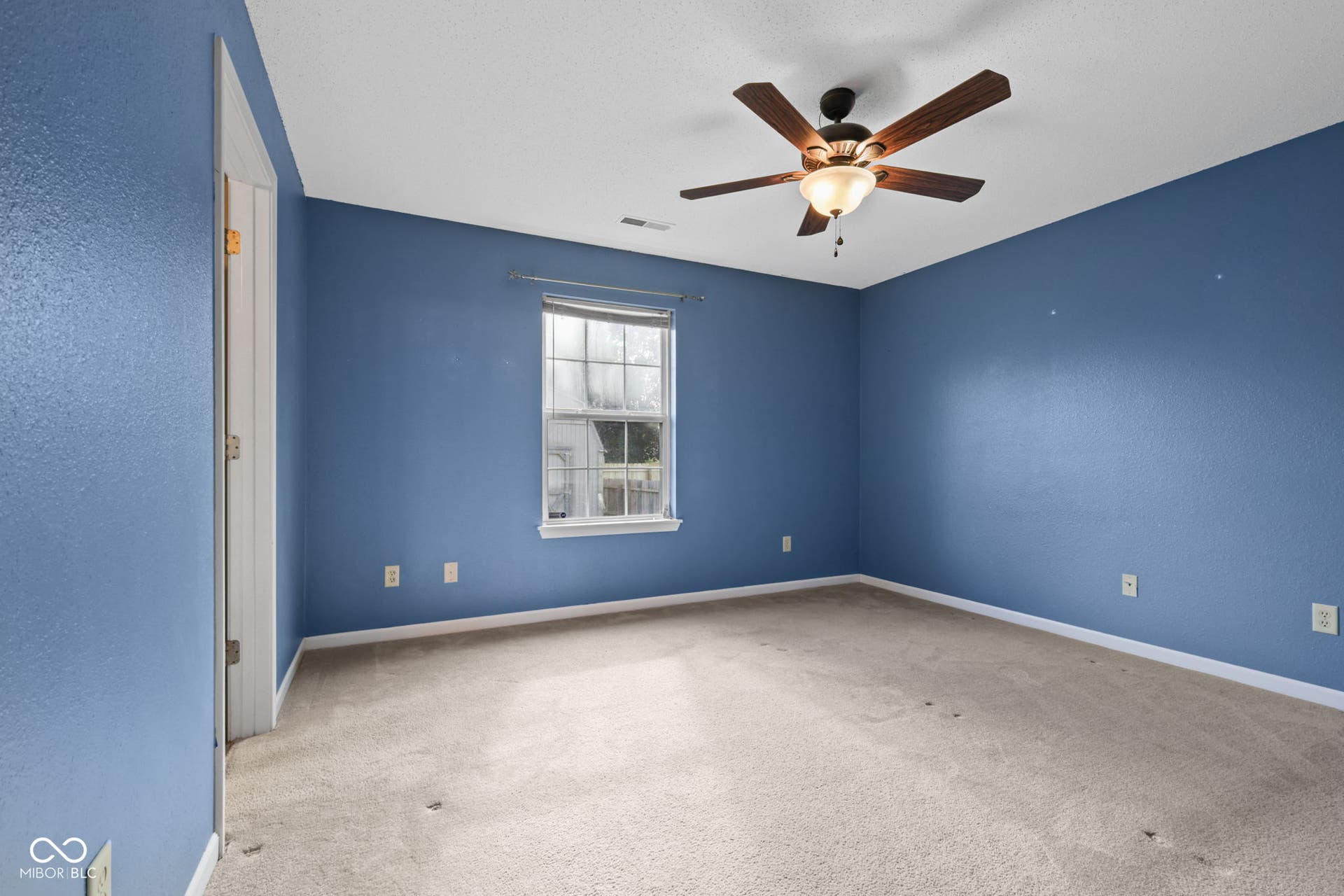 Spacious primary bedroom featuring a private en-suite bathroom and walk-in closet.