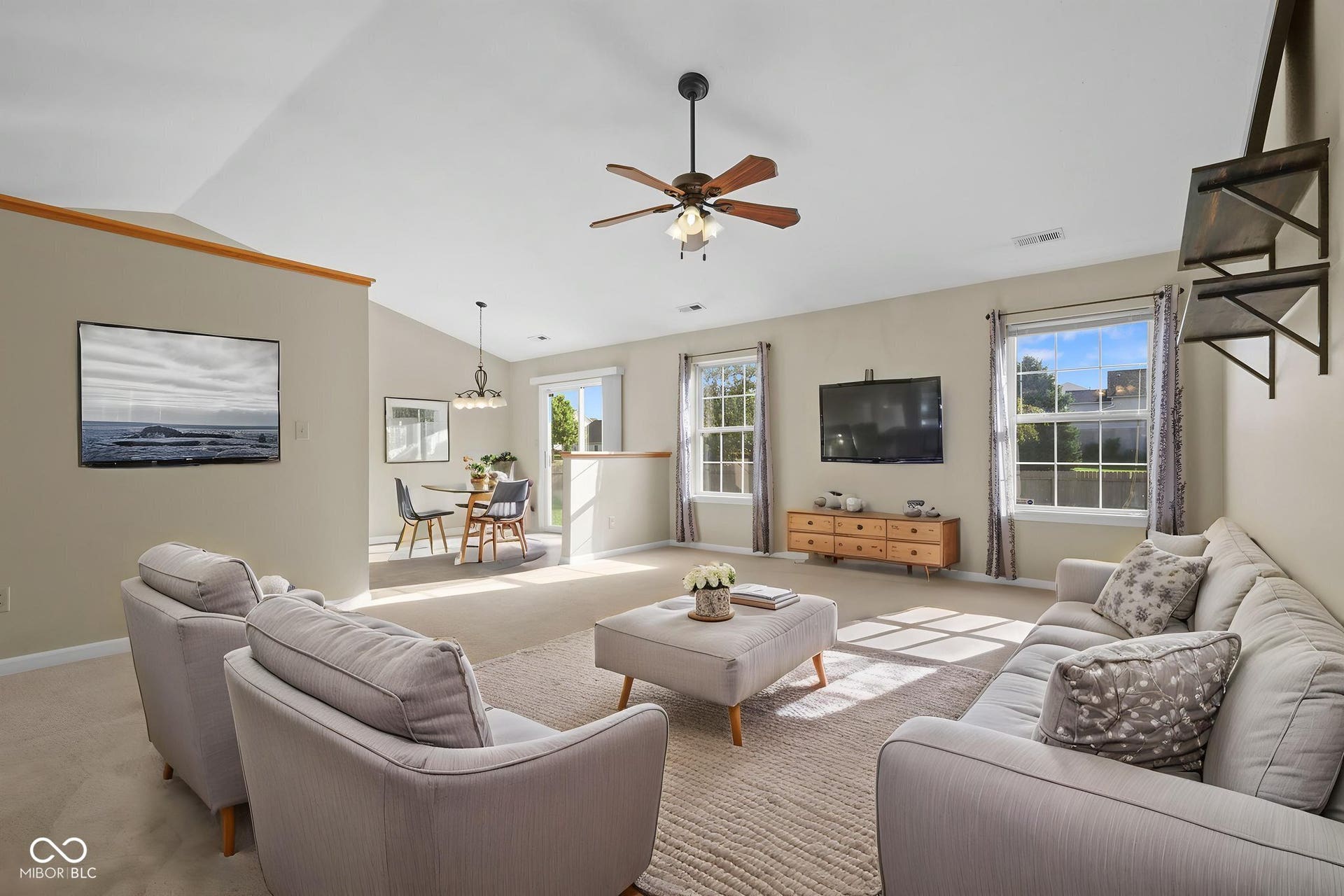 Virtually Altered - Virtually staged living room showcasing the possibilities of this light-filled space with vaulted ceilings and an open flow into the dining area.