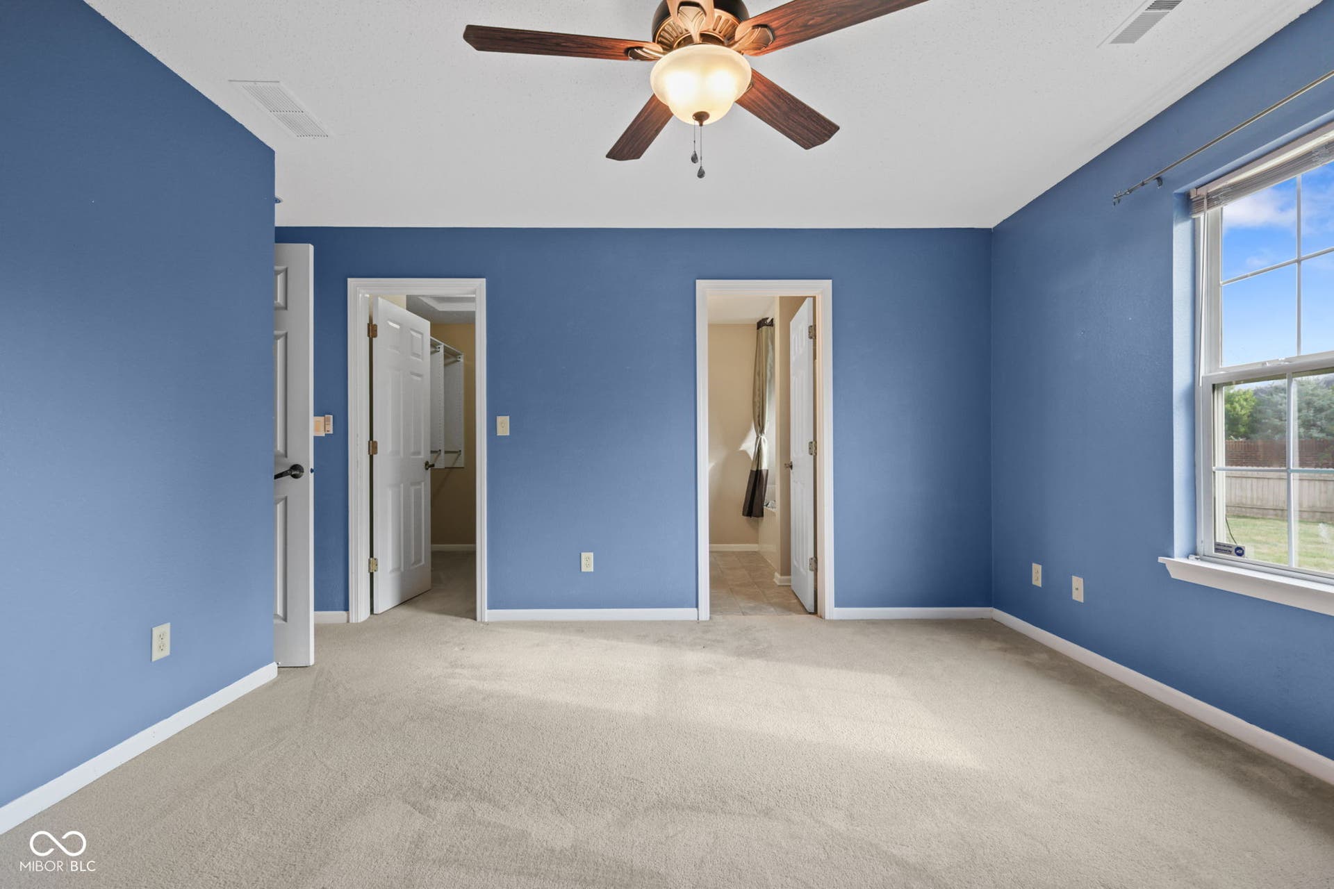 Spacious primary bedroom featuring a private en-suite bathroom and walk-in closet.