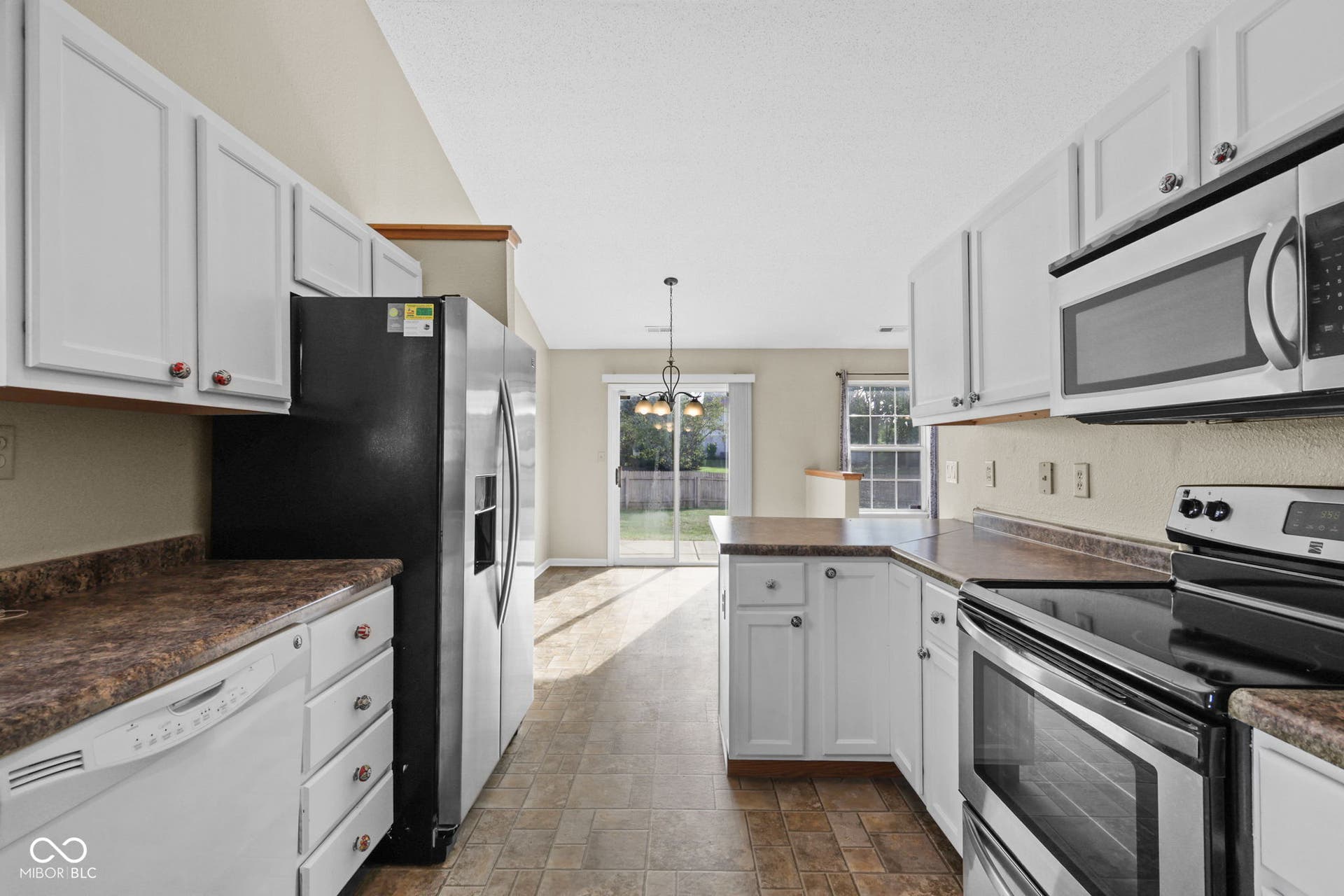 Open kitchen and dining area with direct access and views to the back porch and expansive, fully fenced backyard.