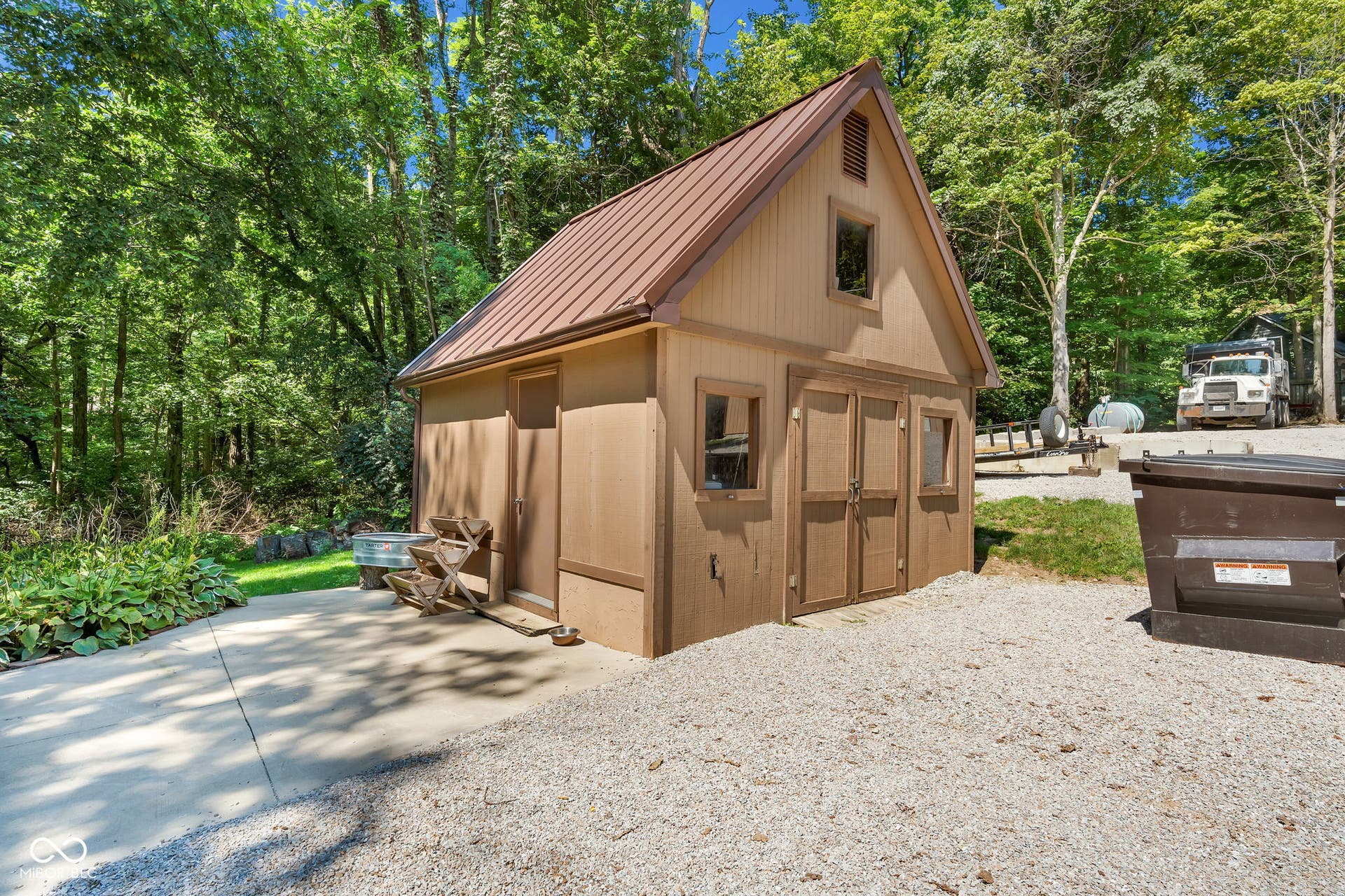 5432 W Whittier Drive, Knightstown, IN 46148 Gable-roofed outbuilding featuring a metal roof, two front-facing windows, double barn doors, and exterior siding