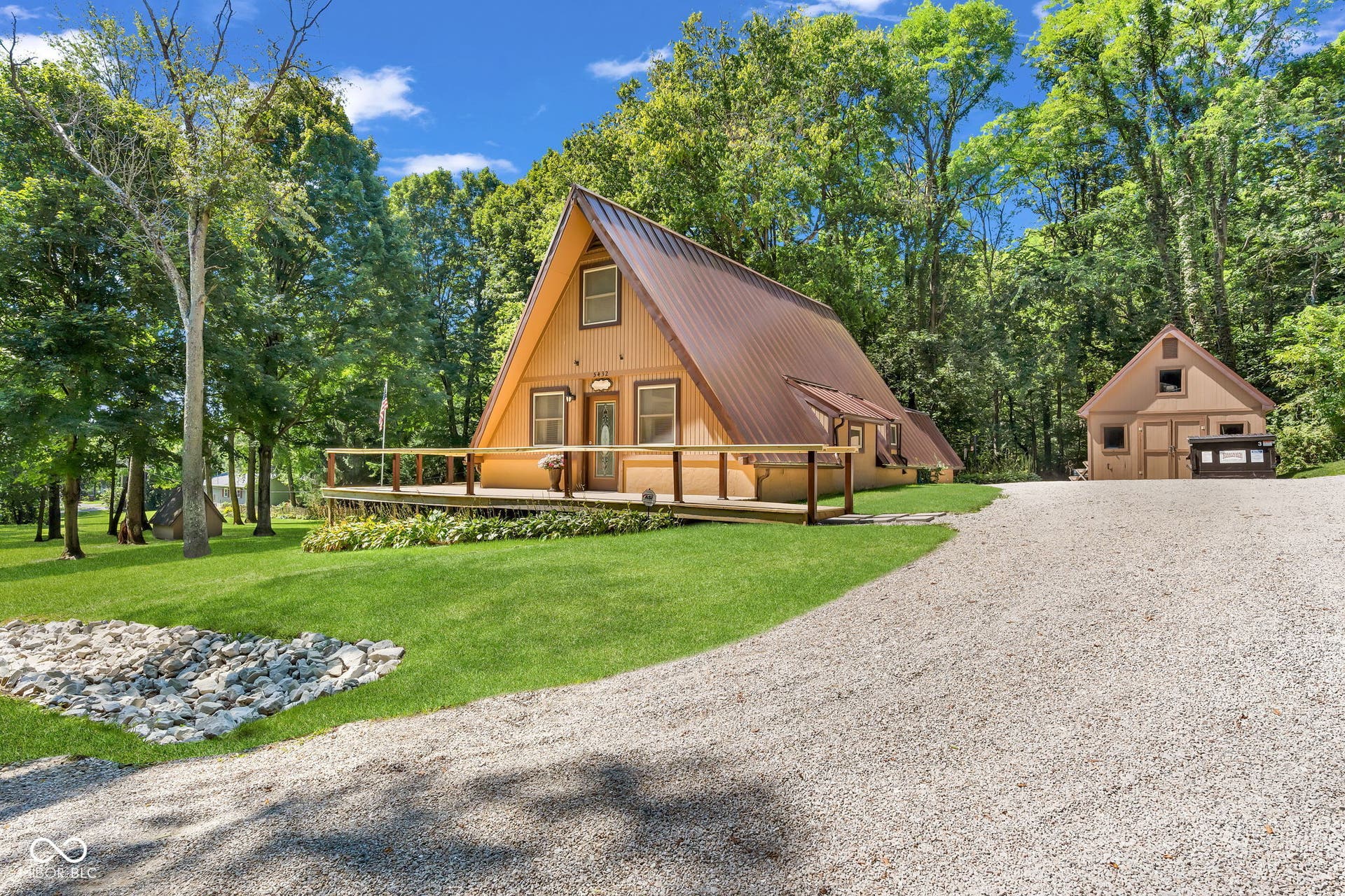 5432 W Whittier Drive, Knightstown, IN 46148 A-Frame residence with warm wood-finish exterior and pitched metal roof, situated on expansive grounds surrounded by mature trees