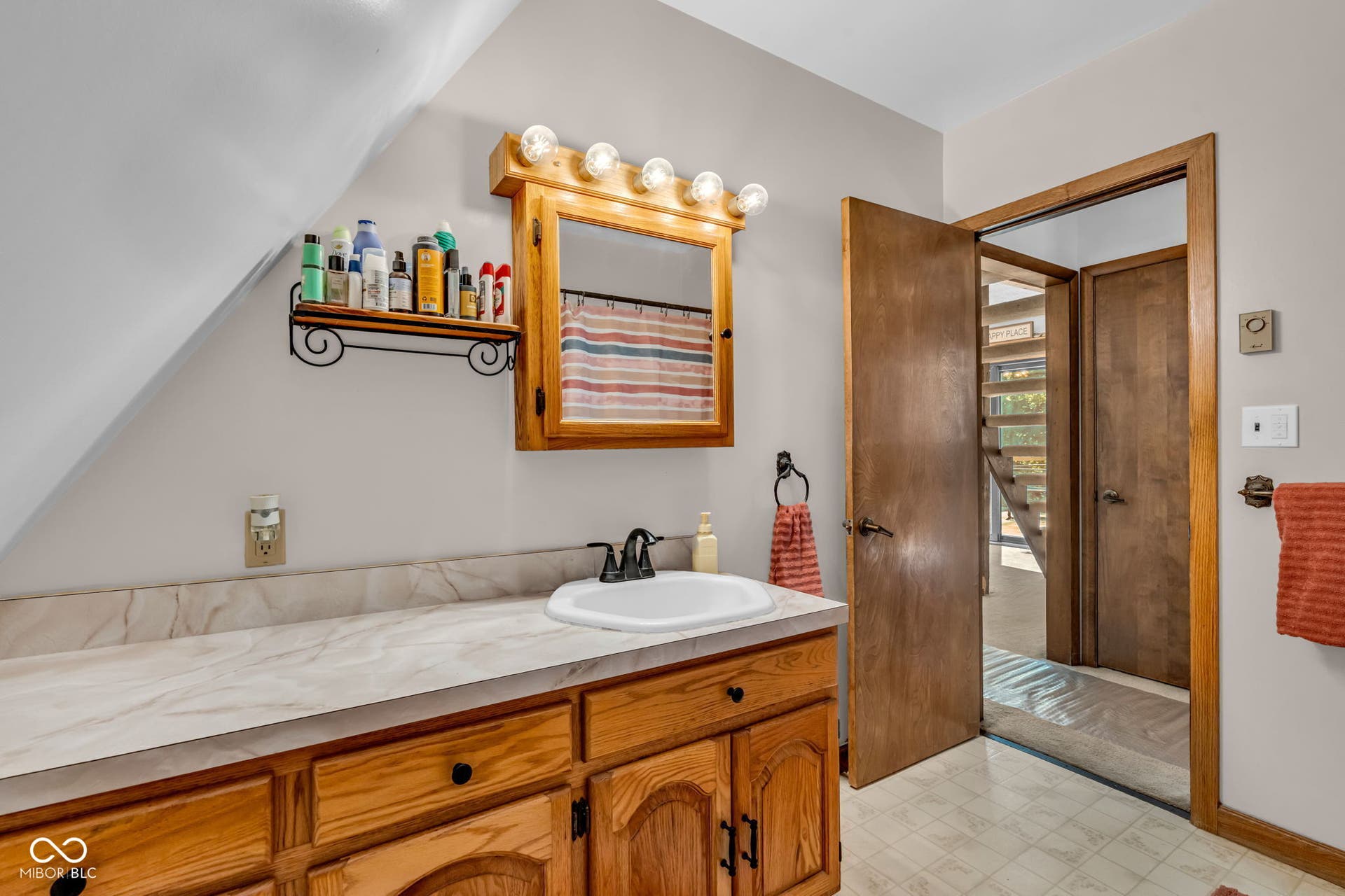 5432 W Whittier Drive, Knightstown, IN 46148 Wood-finish cabinetry with a built-in vanity sink and light-colored countertop