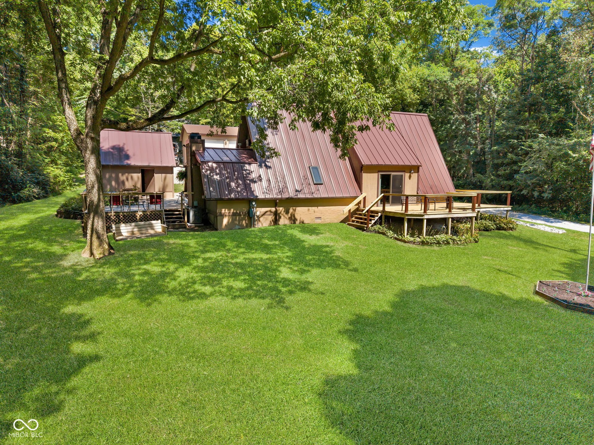 5432 W Whittier Drive, Knightstown, IN 46148 A-frame residence with a metal roof, expansive lawn, and mature trees