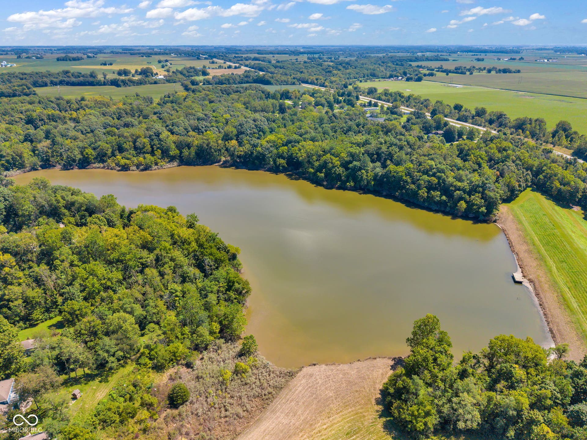 5432 W Whittier Drive, Knightstown, IN 46148 Expansive lakefront property featuring mature tree lines and surrounding agricultural fields