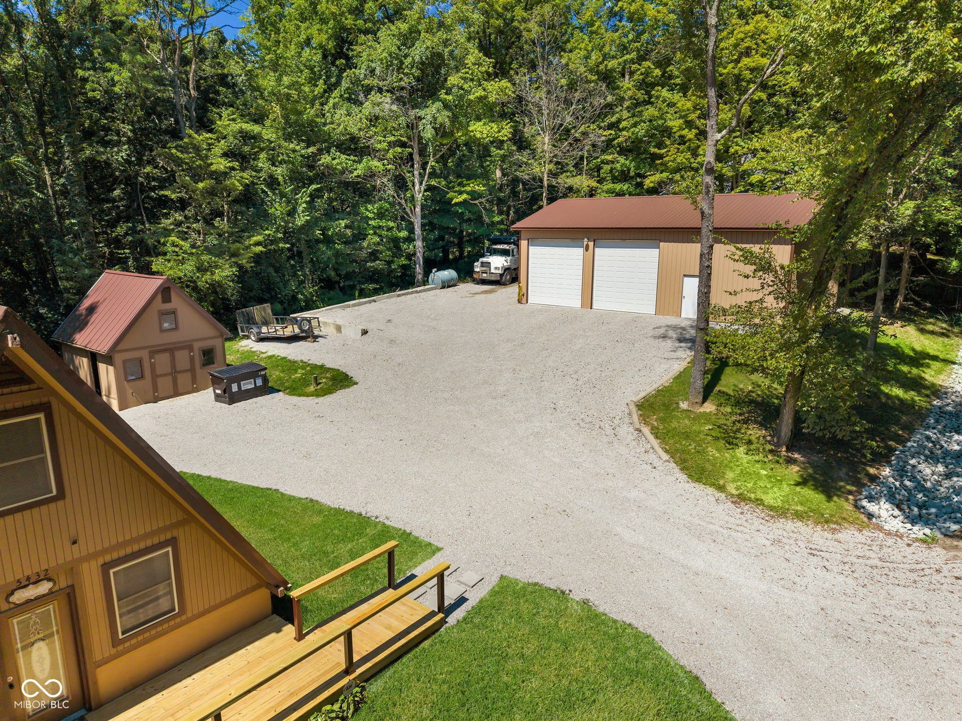5432 W Whittier Drive, Knightstown, IN 46148 Expansive gravel driveway leading to a multi-bay detached garage and a separate shed