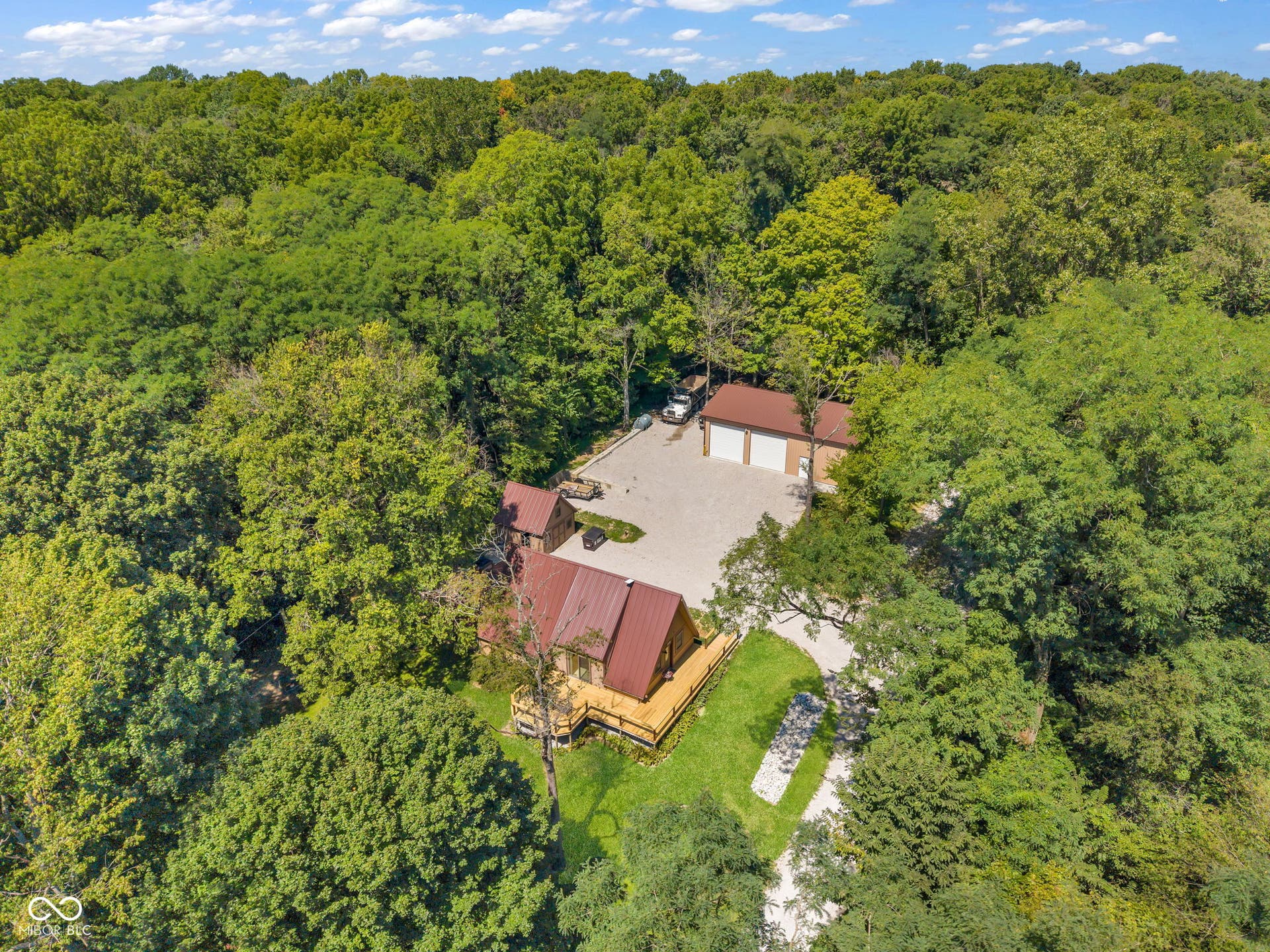 5432 W Whittier Drive, Knightstown, IN 46148 Wooded acreage with a single-family residence, detached two-car garage, gravel driveway, and a private path