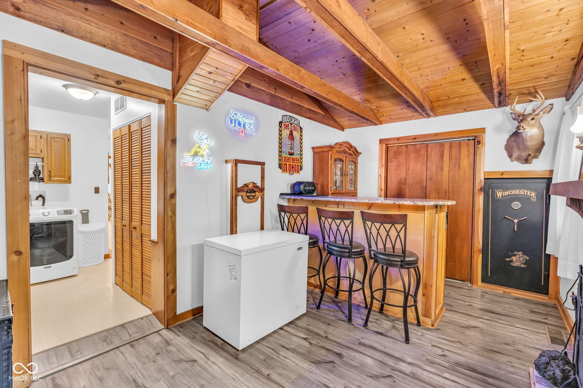 5432 W Whittier Drive, Knightstown, IN 46148 Wood-finish flooring with exposed wood beam ceiling, built-in bar with countertop, and wood-paneled walls