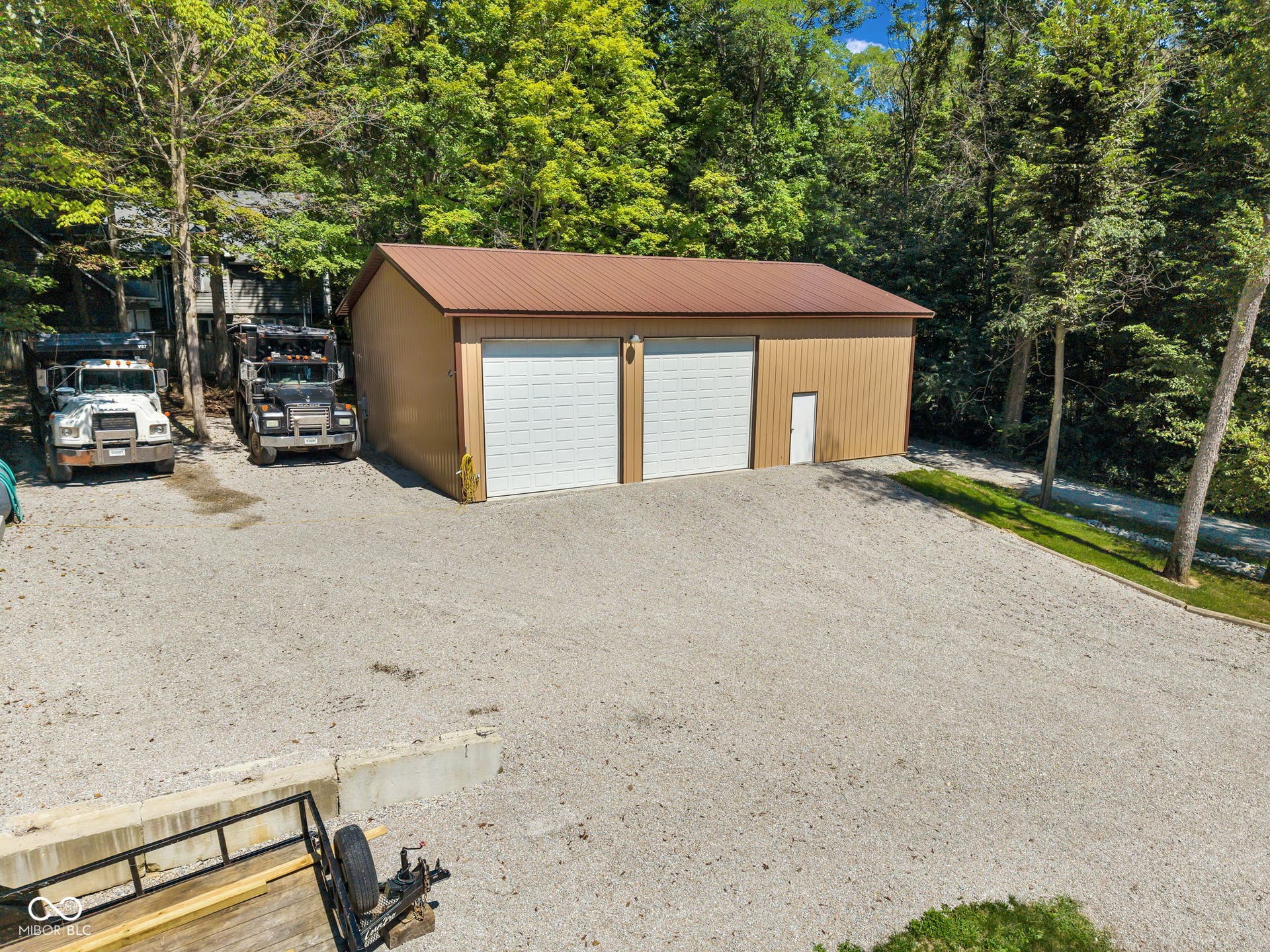 5432 W Whittier Drive, Knightstown, IN 46148 Two-bay detached garage with a metal roof and side entry door, featuring a spacious gravel parking area