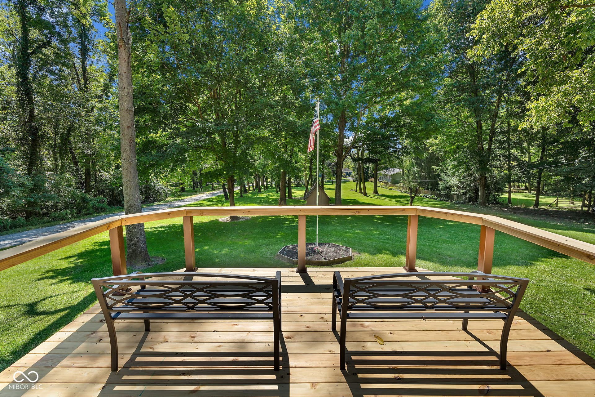 5432 W Whittier Drive, Knightstown, IN 46148 Spacious wood deck with natural wood railing, overlooking an expansive lawn and mature trees