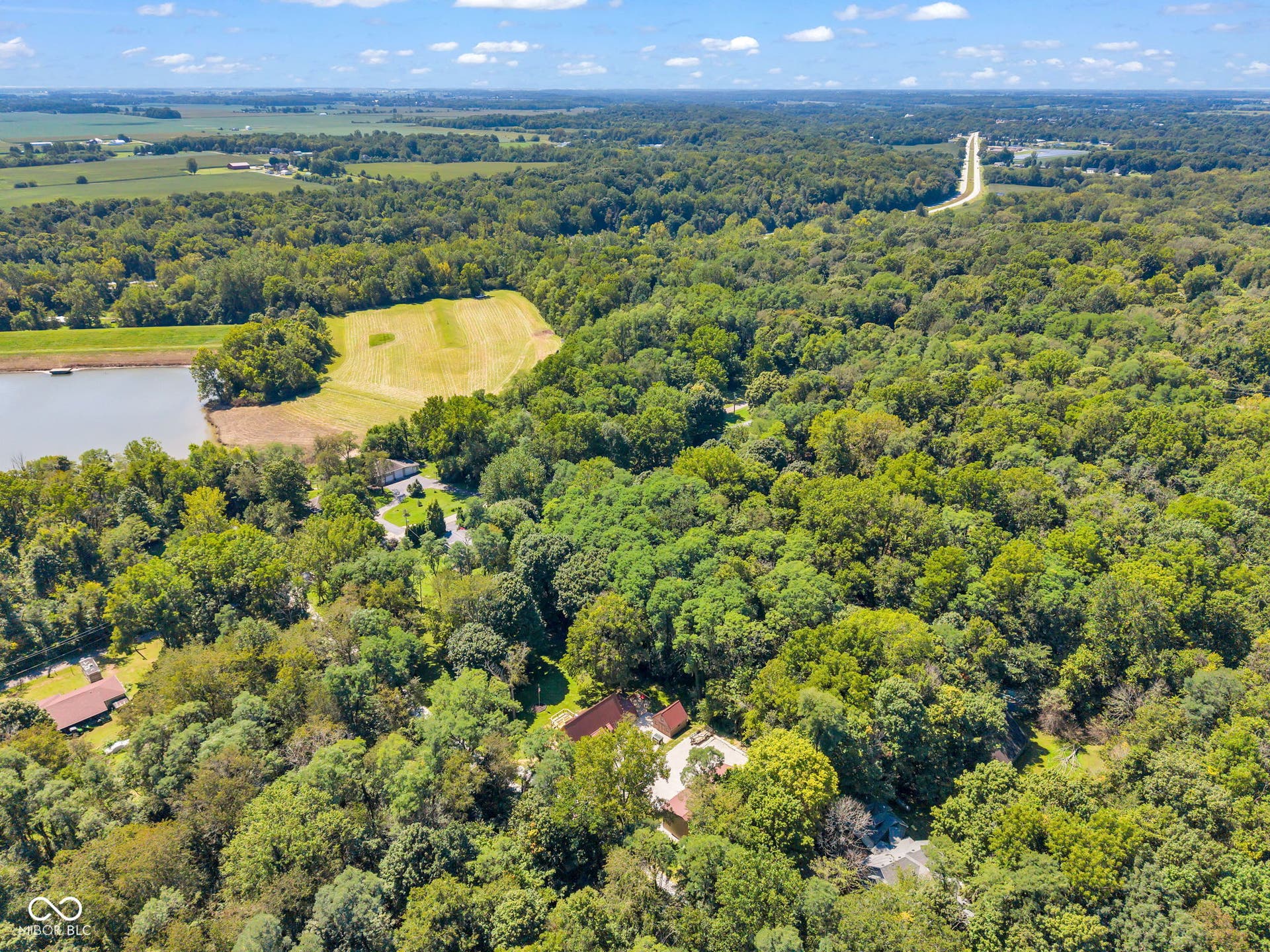 5432 W Whittier Drive, Knightstown, IN 46148 Expansive treed acreage featuring multiple structures, a private lake, and open fields