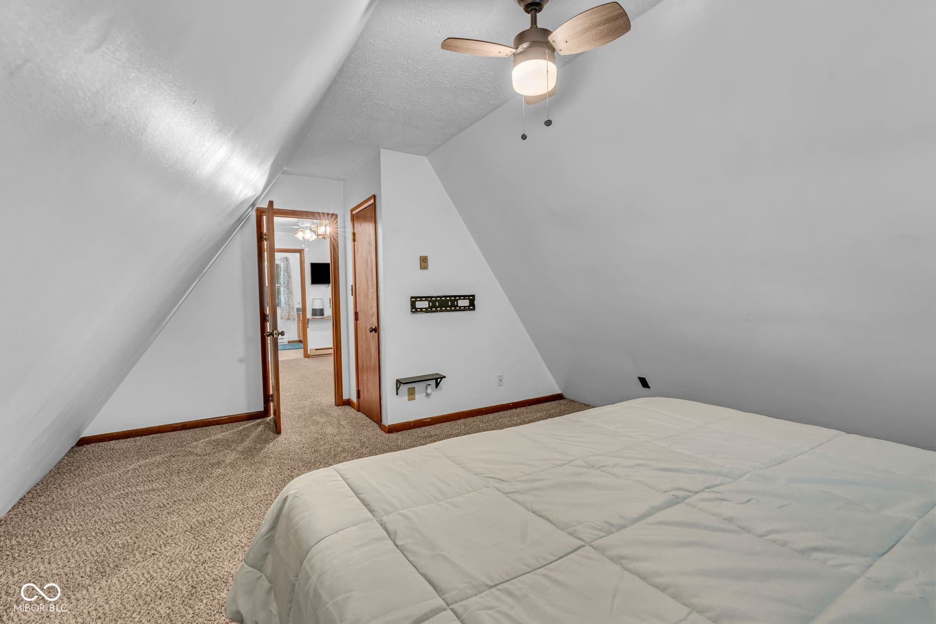 5432 W Whittier Drive, Knightstown, IN 46148 Carpeted room with a sloped ceiling, wood-finish trim, and a ceiling fan with integrated lighting