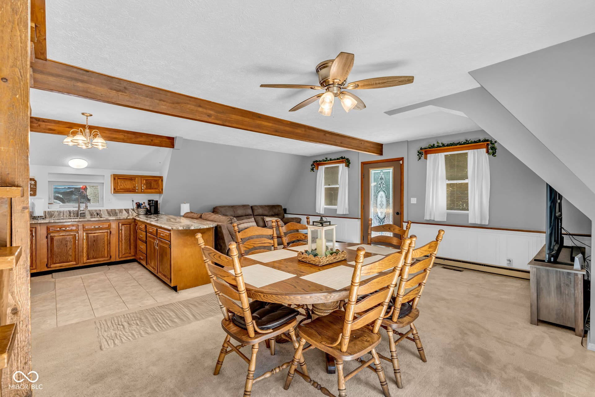 5432 W Whittier Drive, Knightstown, IN 46148 Exposed wood beams, ceiling fan, wood-finish cabinetry, tile flooring, and a decorative glass entry door
