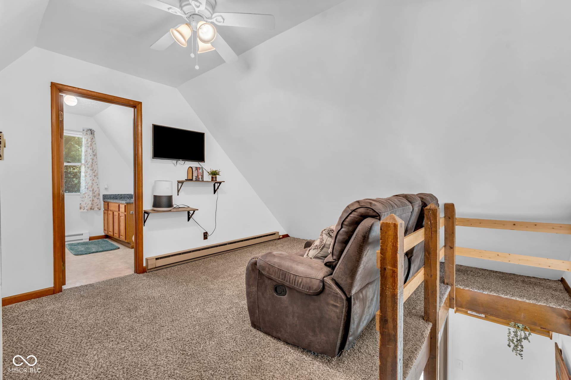 5432 W Whittier Drive, Knightstown, IN 46148 Bedroom 3 or bonus room Carpeted living area with sloped ceilings, ceiling fan, natural wood trim, and wall-mounted shelving