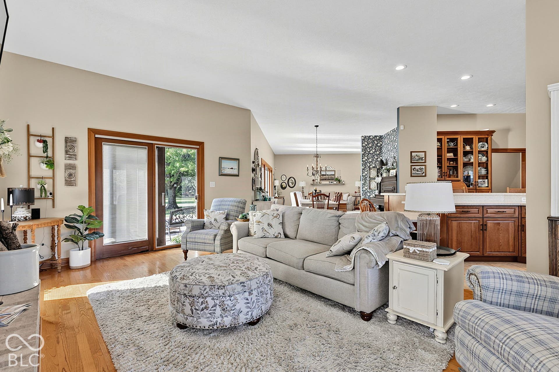Vaulted ceilings with recessed lighting, wood-finish flooring, and sliding glass door