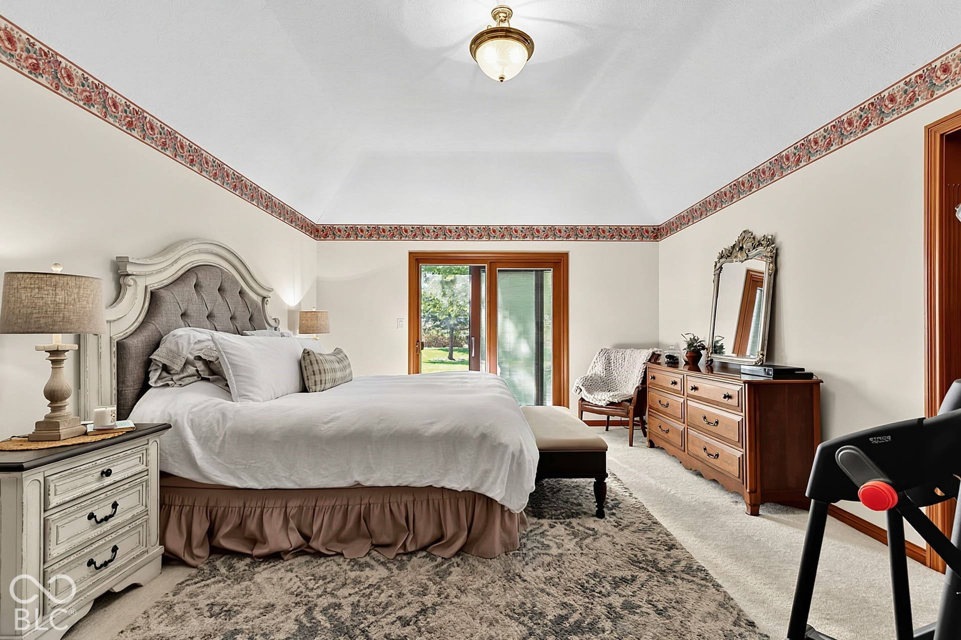 Vaulted ceiling, sliding glass door, wood-finish trim, and recessed lighting