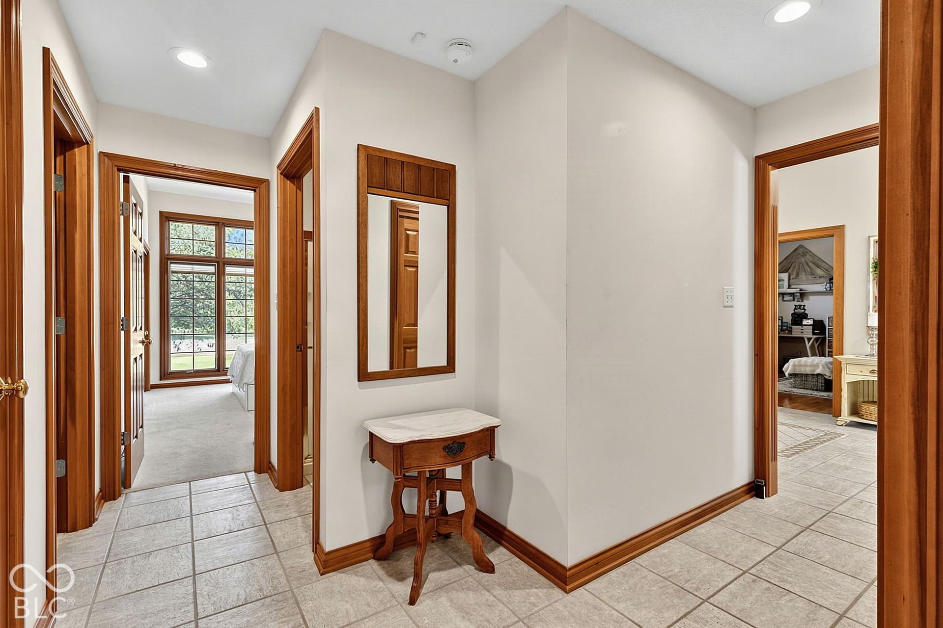 Tiled flooring entrance with wood-finish trim and doors, recessed lighting, and a large window