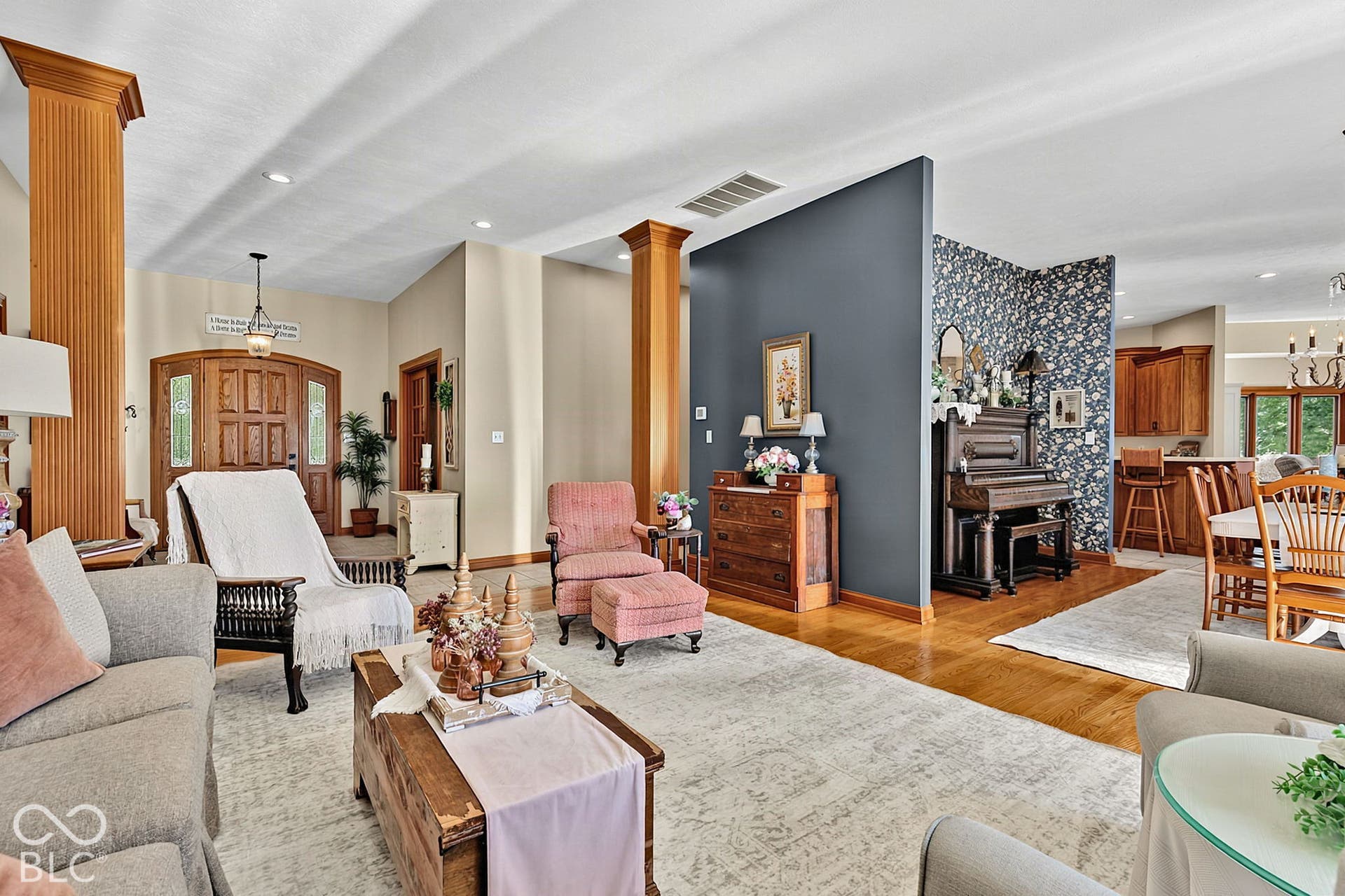 Hardwood flooring throughout, recessed lighting, and a detailed wood entry door with transom