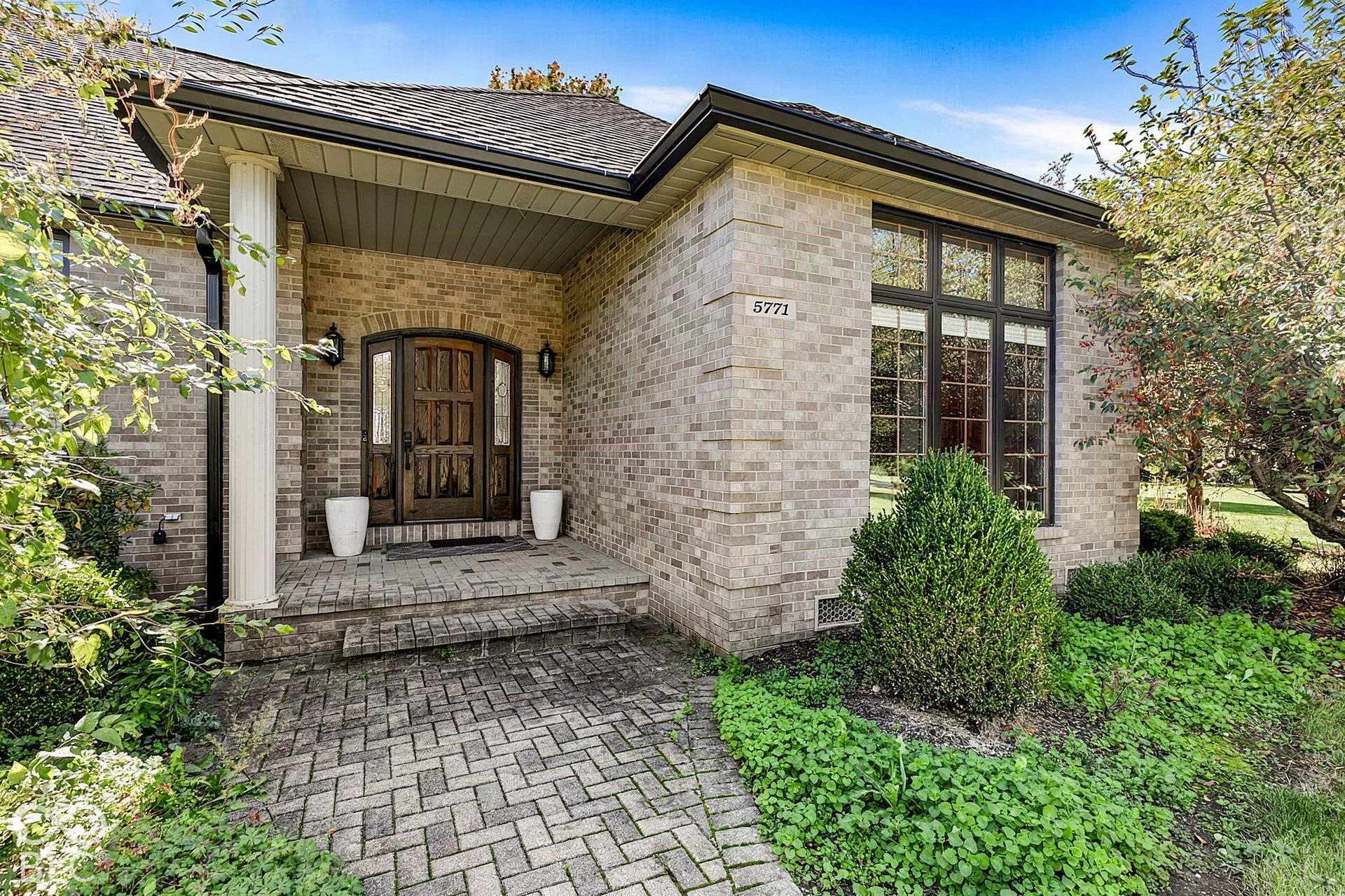 Brick exterior with a herringbone paver walkway and steps