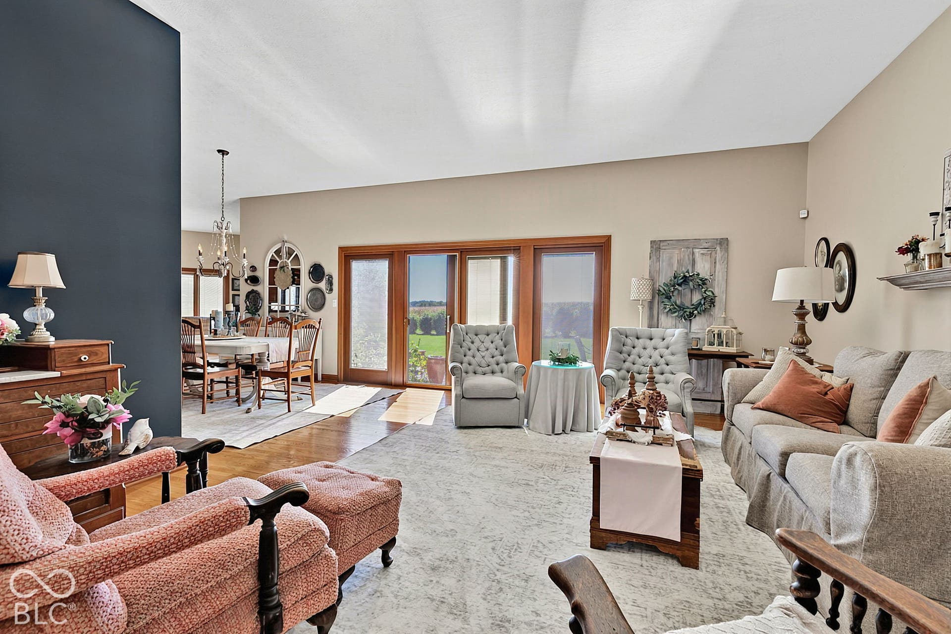 Vaulted ceiling, recessed lighting, wood-finish flooring, wood-frame glass doors, chandelier