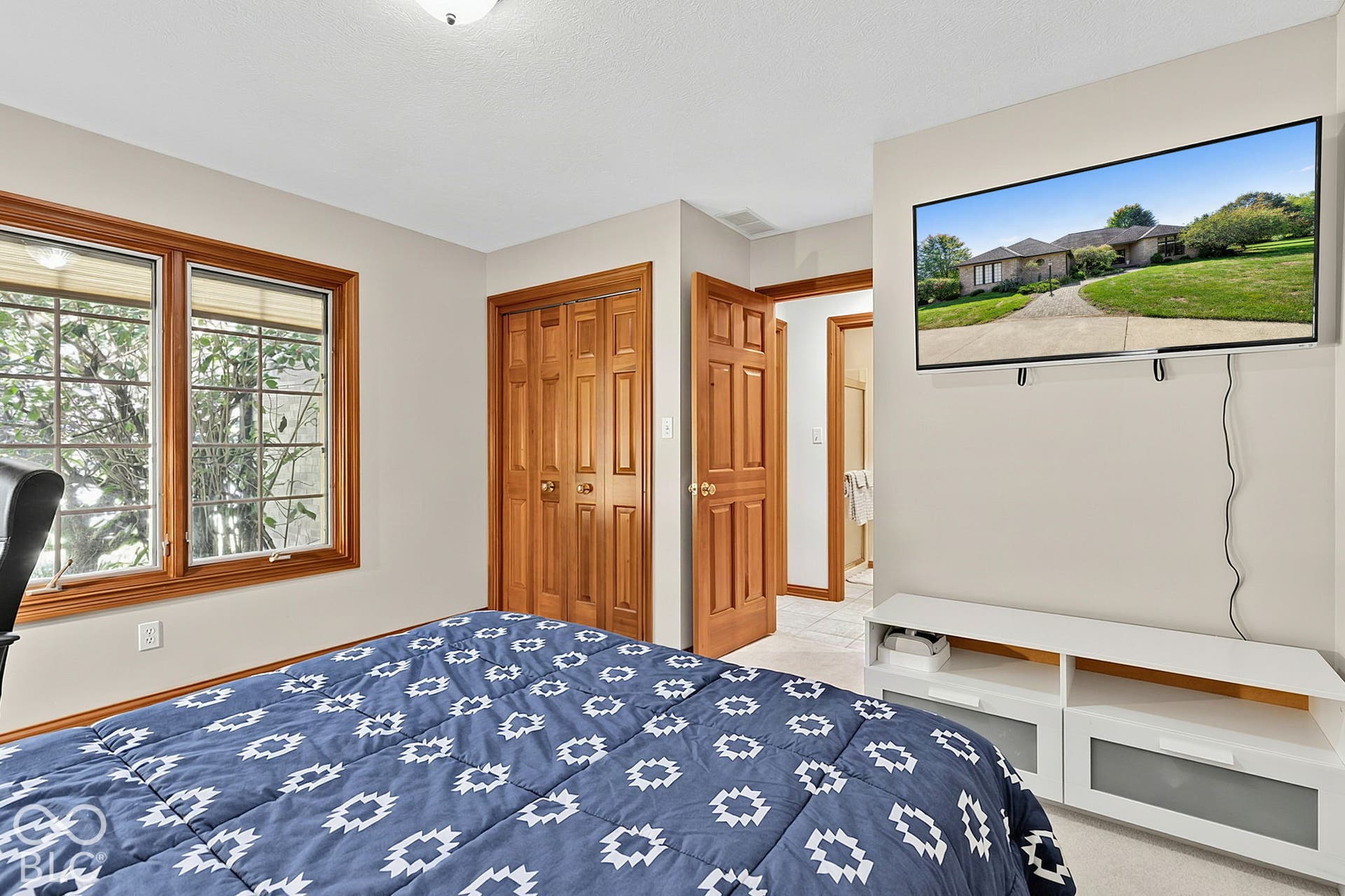 Double window with wood-finish trim, wood-finish bi-fold closet doors, and wood-finish interior door