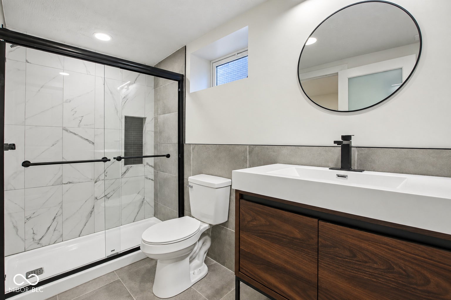 Full Bathroom in basement: Walk-in shower with large format tile surround, glass enclosure, and recessed niche