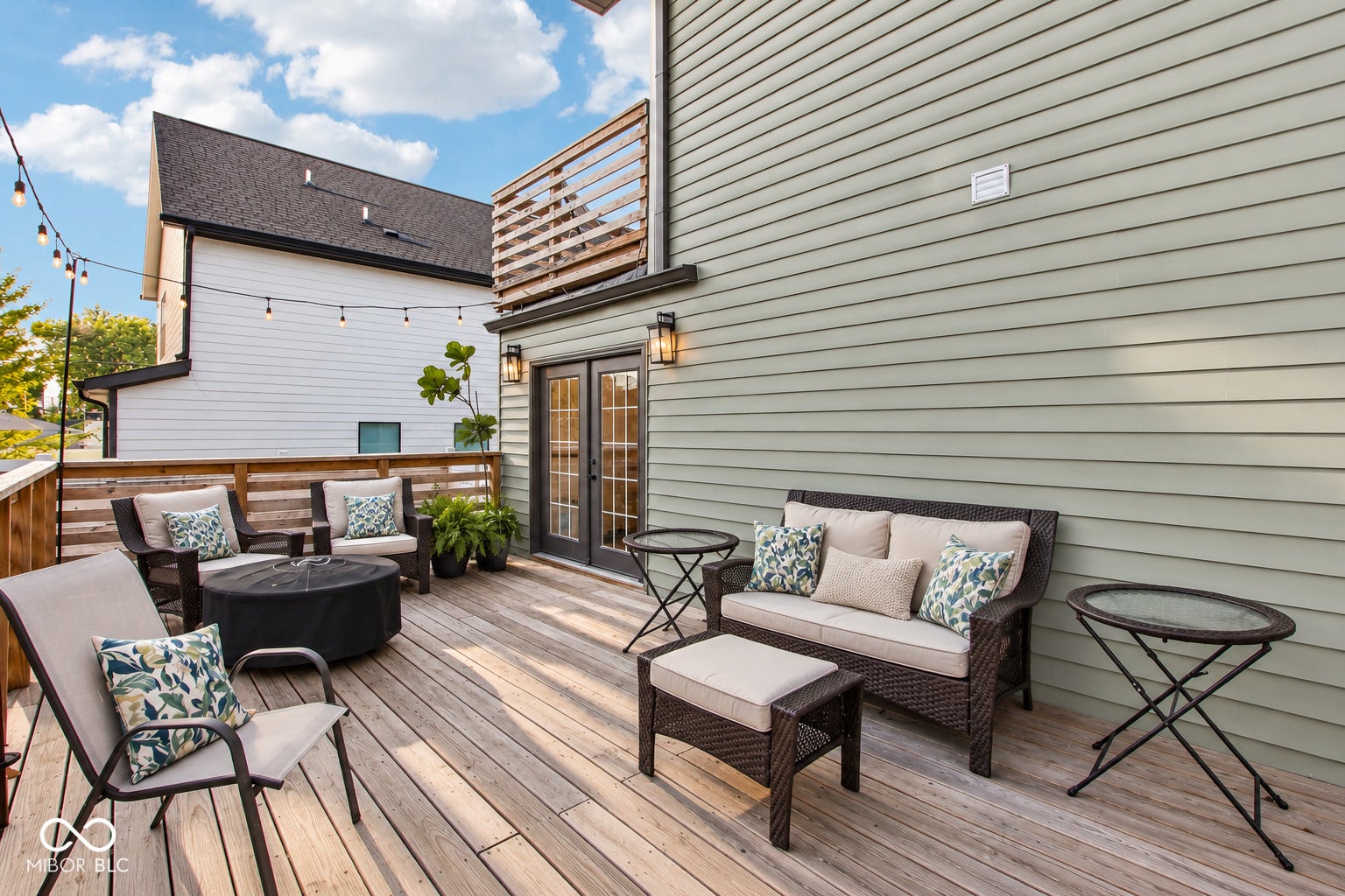 Expansive outdoor deck featuring wood flooring, privacy screen, and direct access through double doors