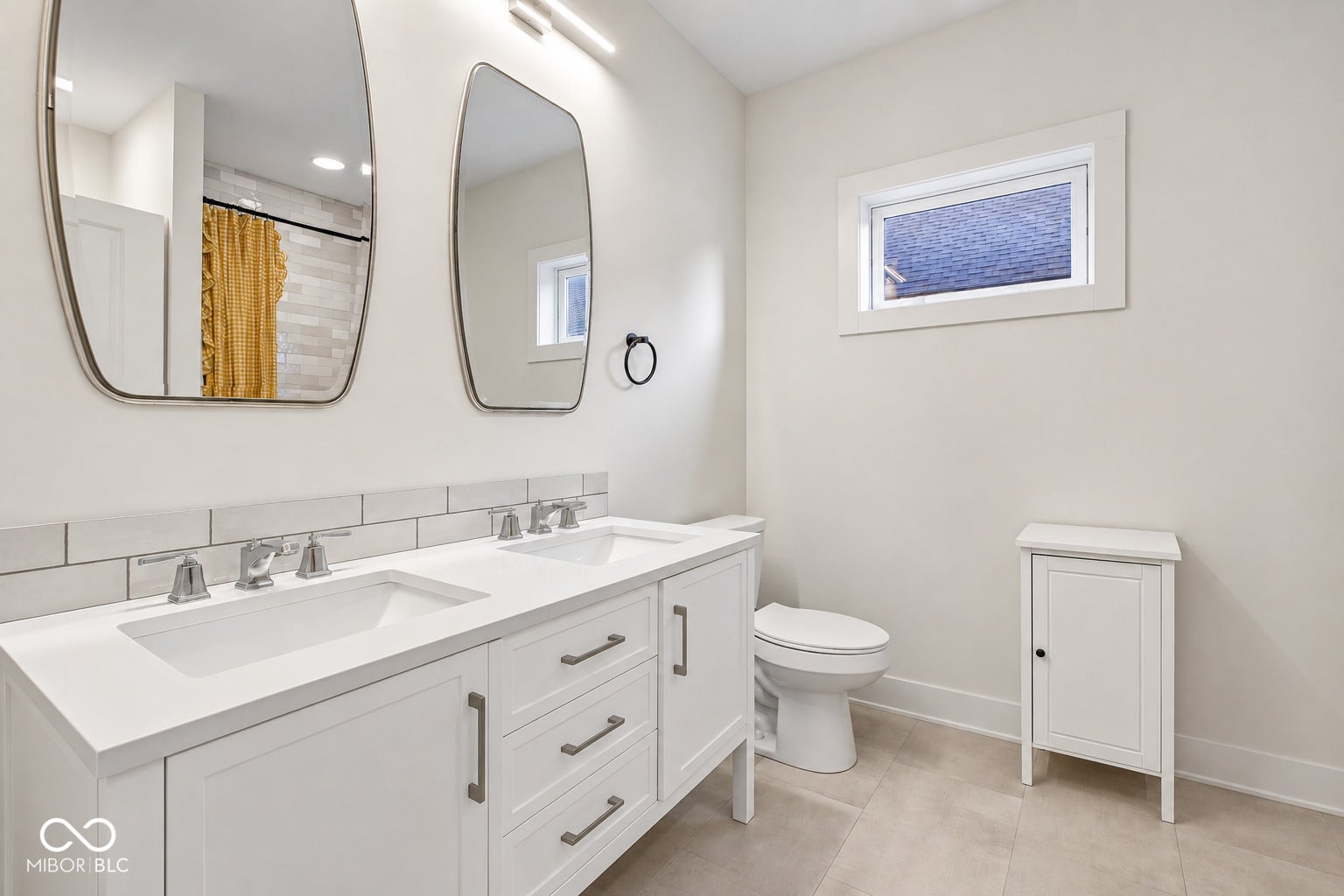 Double vanity with dual undermount sinks, white cabinetry, and brushed nickel hardware