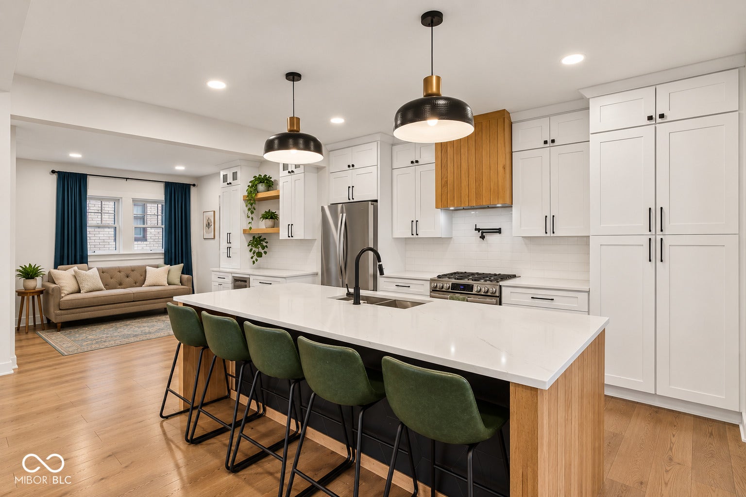 Kitchen featuring white shaker cabinetry, stainless steel appliances, a center island with countertop seating, wood-finish flooring, and recessed lighting