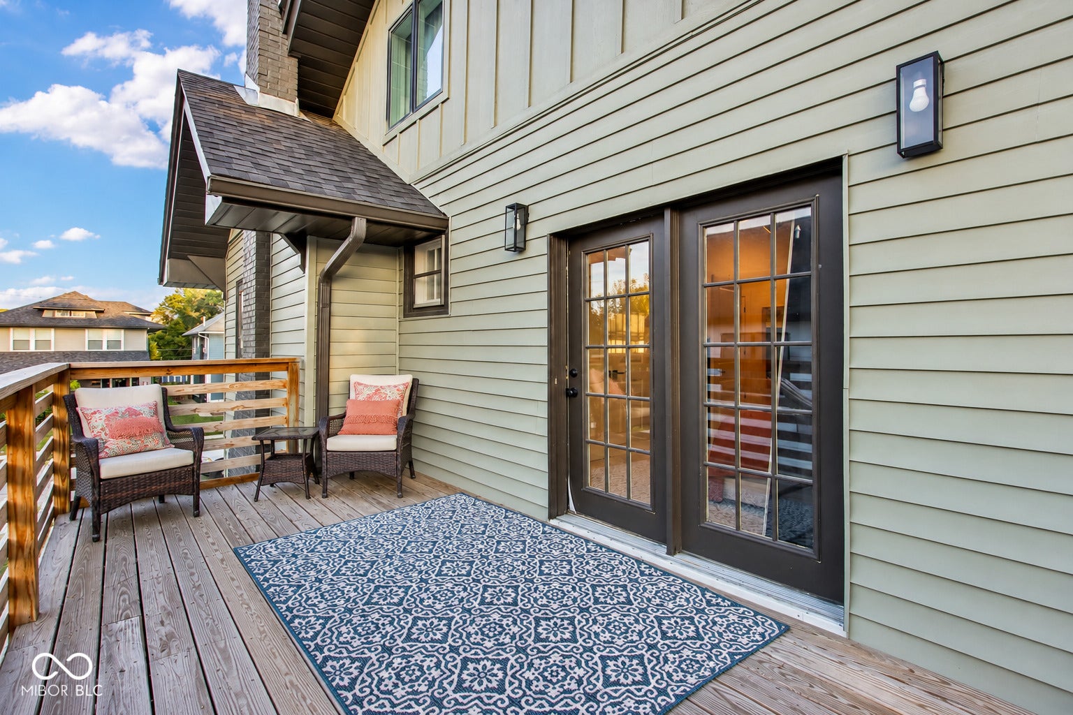 Virtually Altered - Upper Deck off primary bedroom: Exterior deck with wood railing, dual glass-paned doors, and horizontal siding