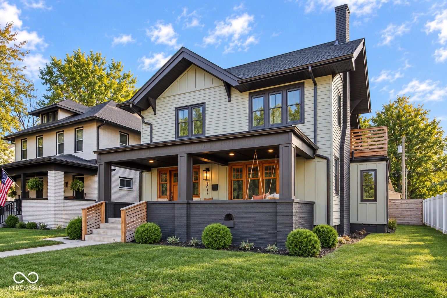 Contemporary exterior with light siding, dark trim, a covered porch, a prominent chimney, and a second-story balcony