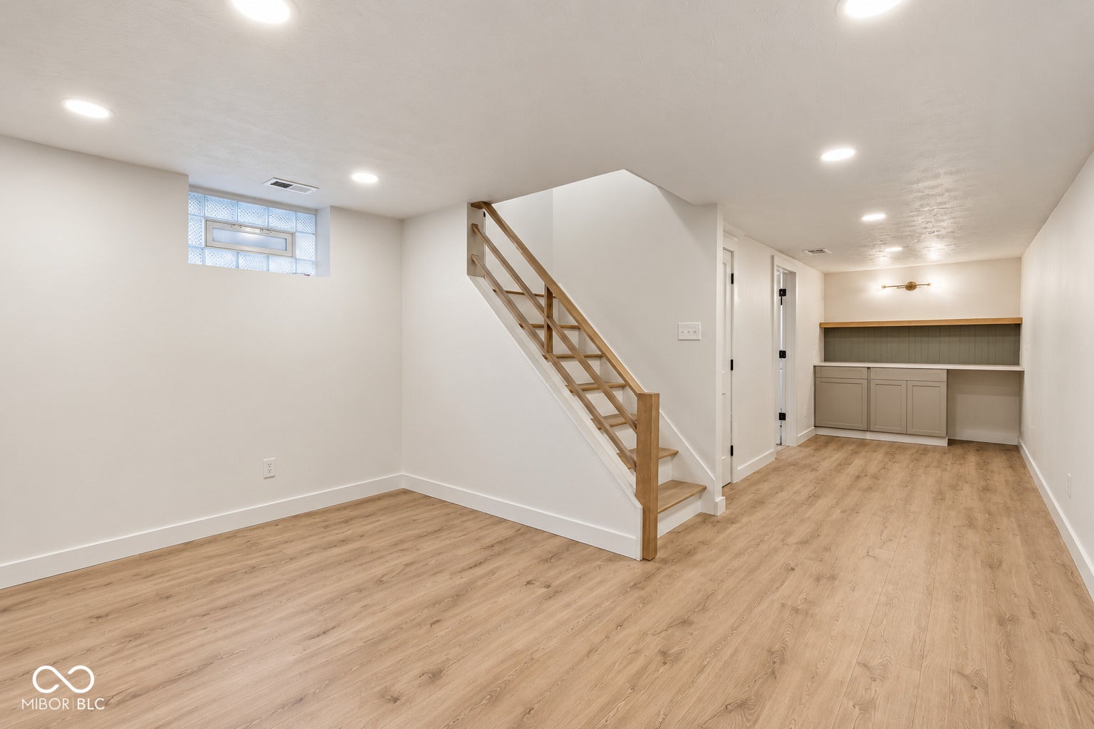 Virtually Altered - Recessed lighting, wood-finish flooring, staircase with natural wood handrail, built-in cabinetry, and subway tile backsplash