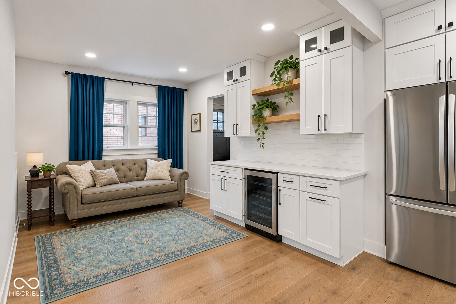 Virtually Altered - Wood-finish flooring throughout, complemented by a white built-in beverage refrigerator