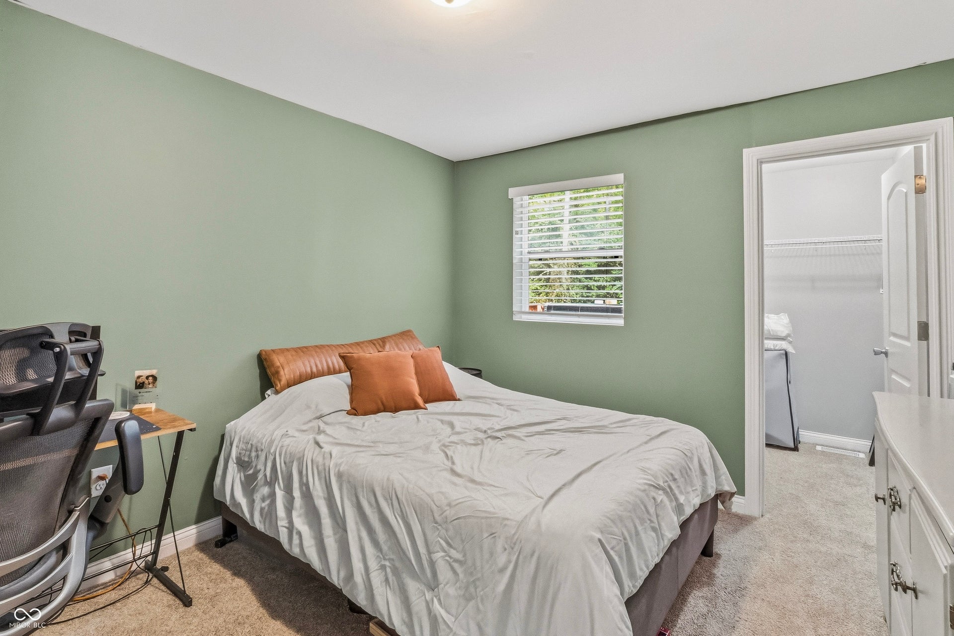 Soft green walls complement the neutral carpeting, walk-in closet.