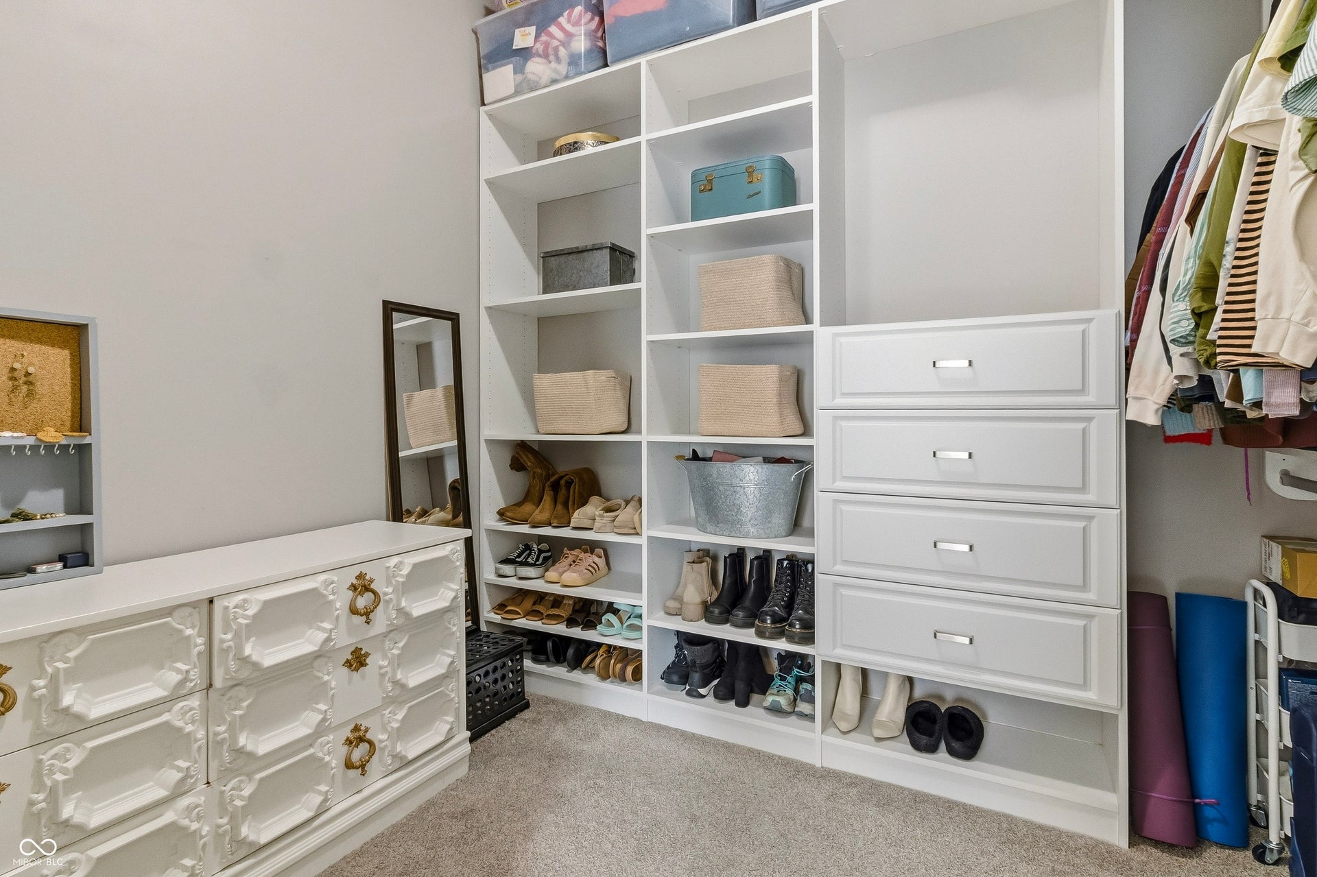 Bonus room with added custom built-in shelving, white cabinetry, and full-height storage area