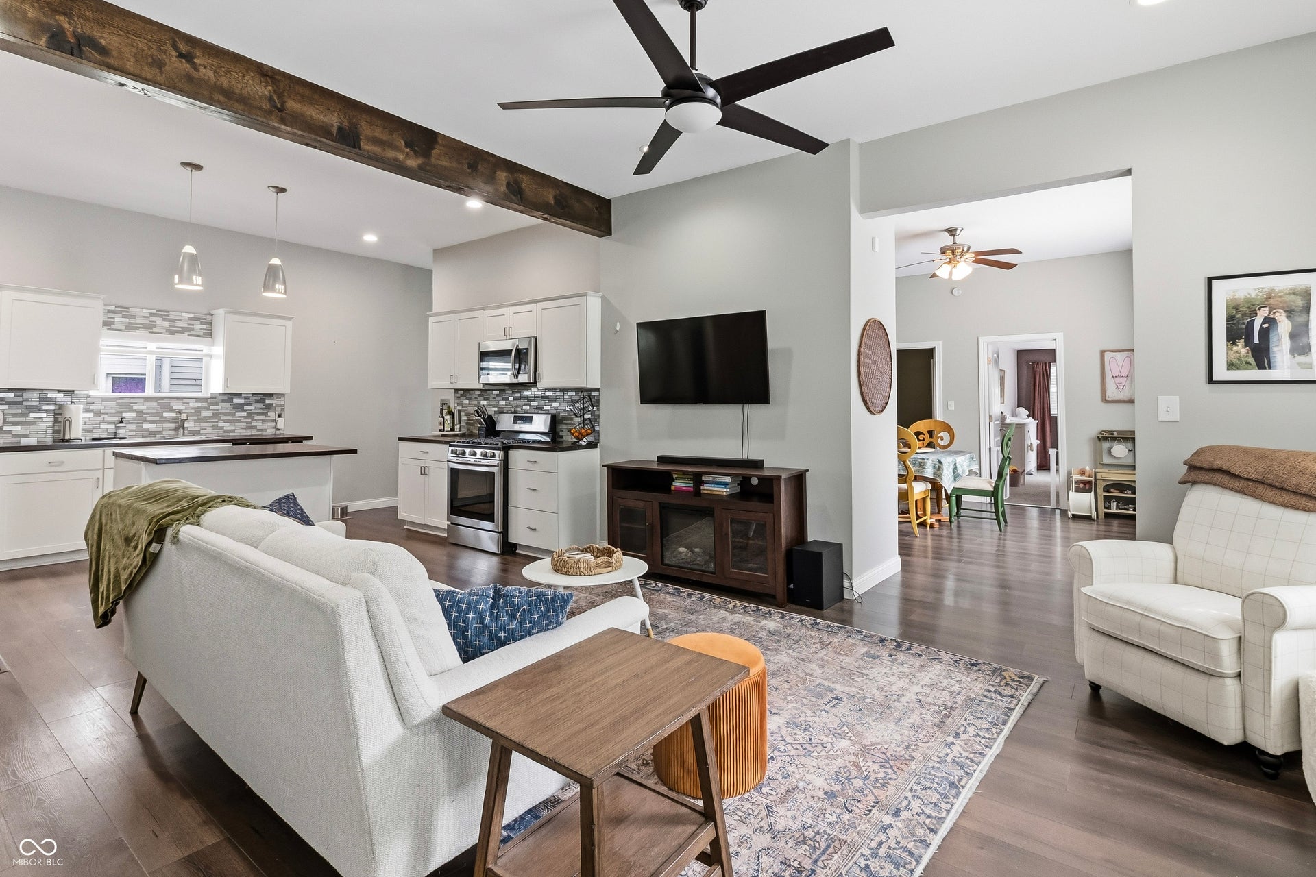 Open-concept living area featuring LVP flooring, a contemporary ceiling fan, and open to the kitchen