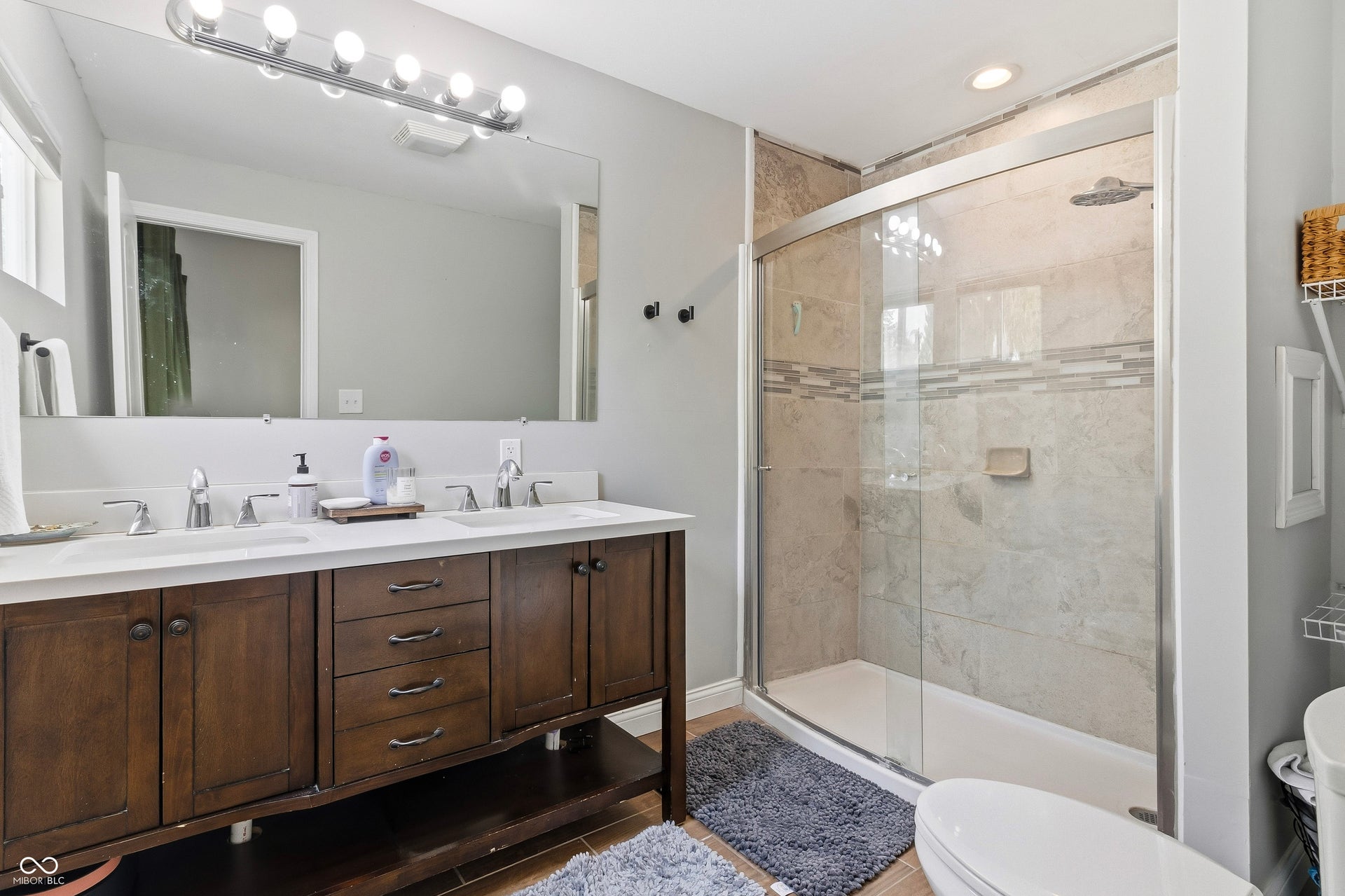 Dual vanity with white countertops, dark wood cabinetry, and chrome fixtures