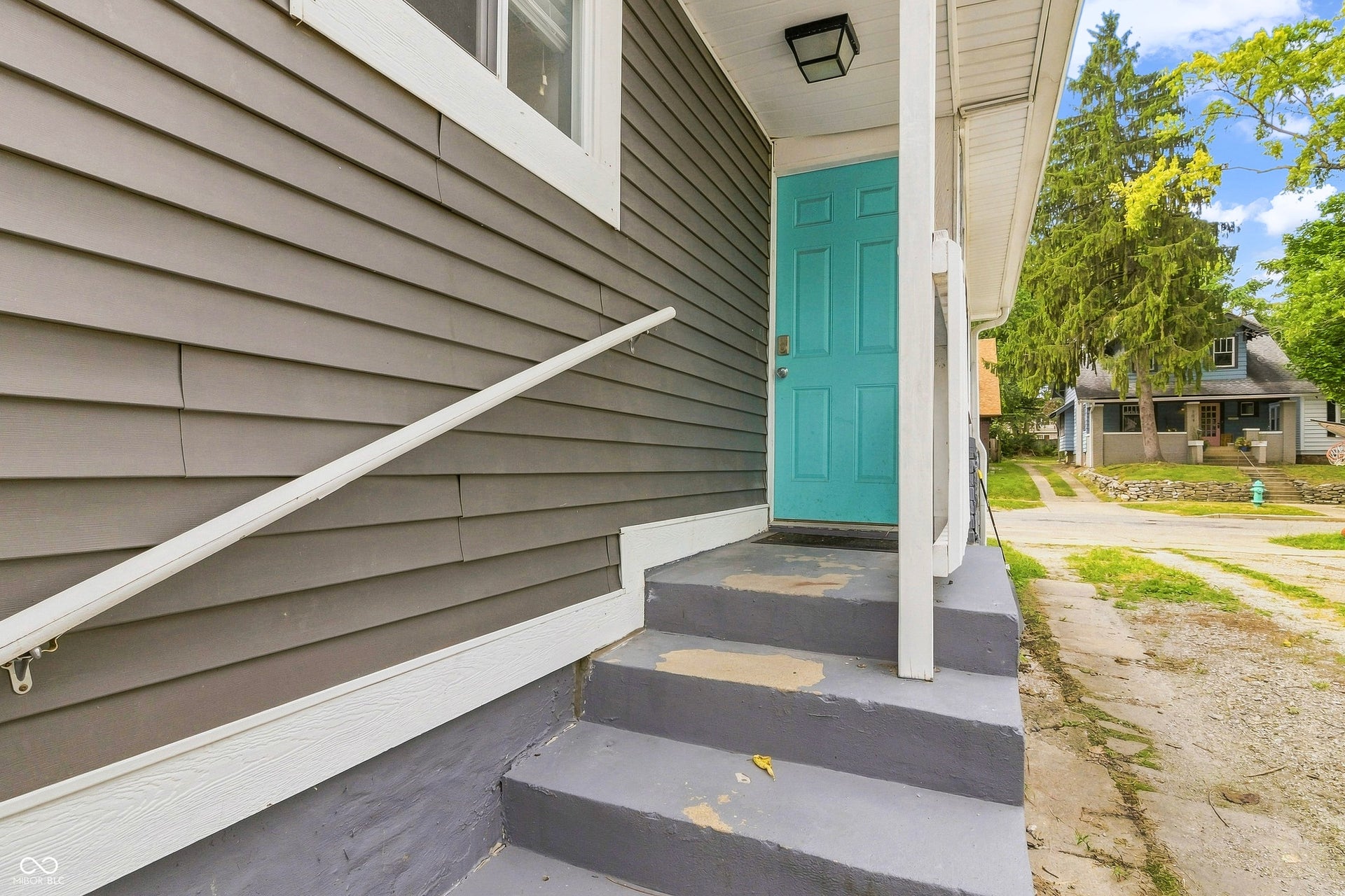 Side-door entryway off of gravel driveway