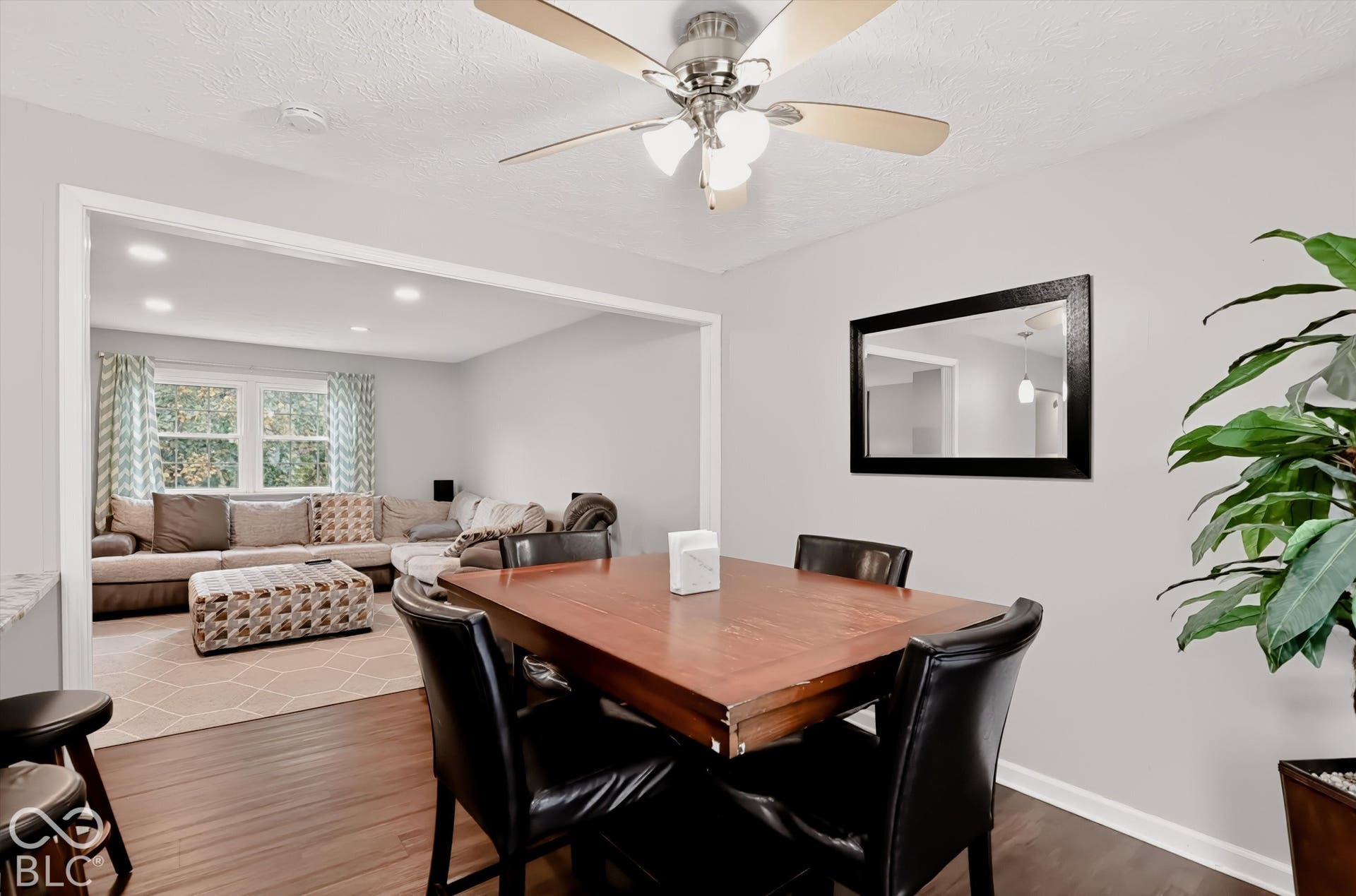 Neutral interior featuring wood-finish flooring, a ceiling fan with multi-light fixture, recessed lighting, and a large wall-mounted mirror